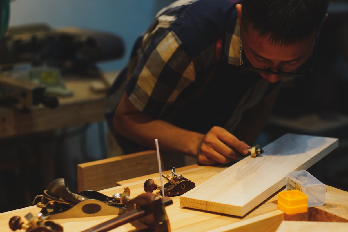 Carpintero trabajando la madera con herramientas en un taller