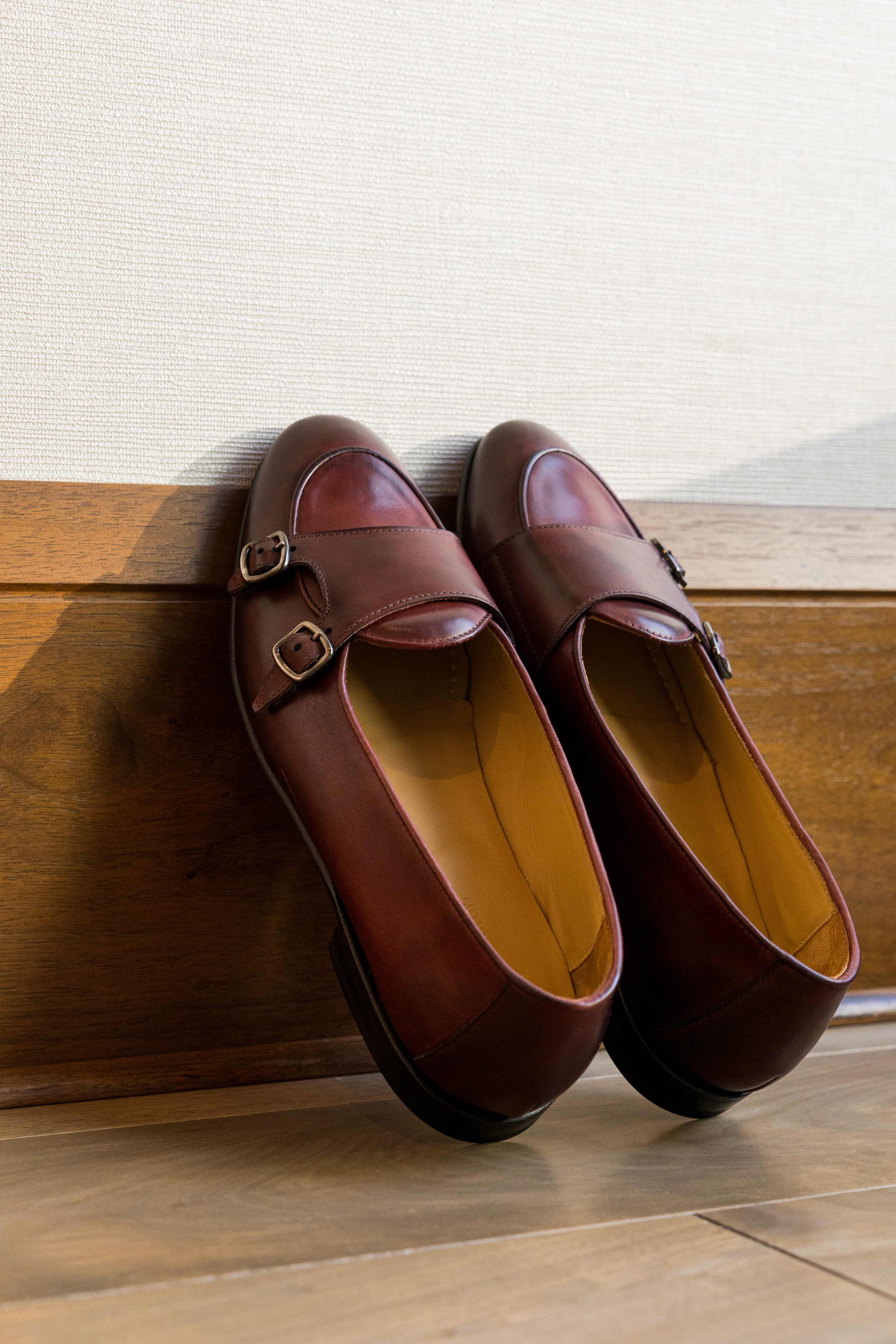 Don Marrón member wearing a tailored gray suit and white shirt walking along a stone wall, embodying Italian craftsmanship, modern style, and quiet confidence.