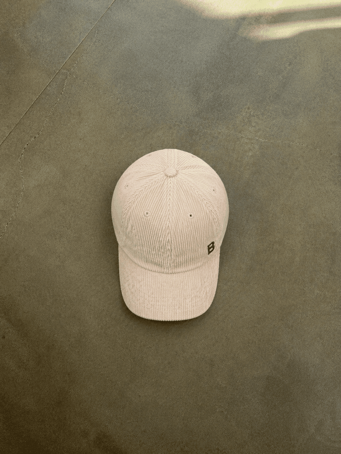 Beige cap on a textured green surface