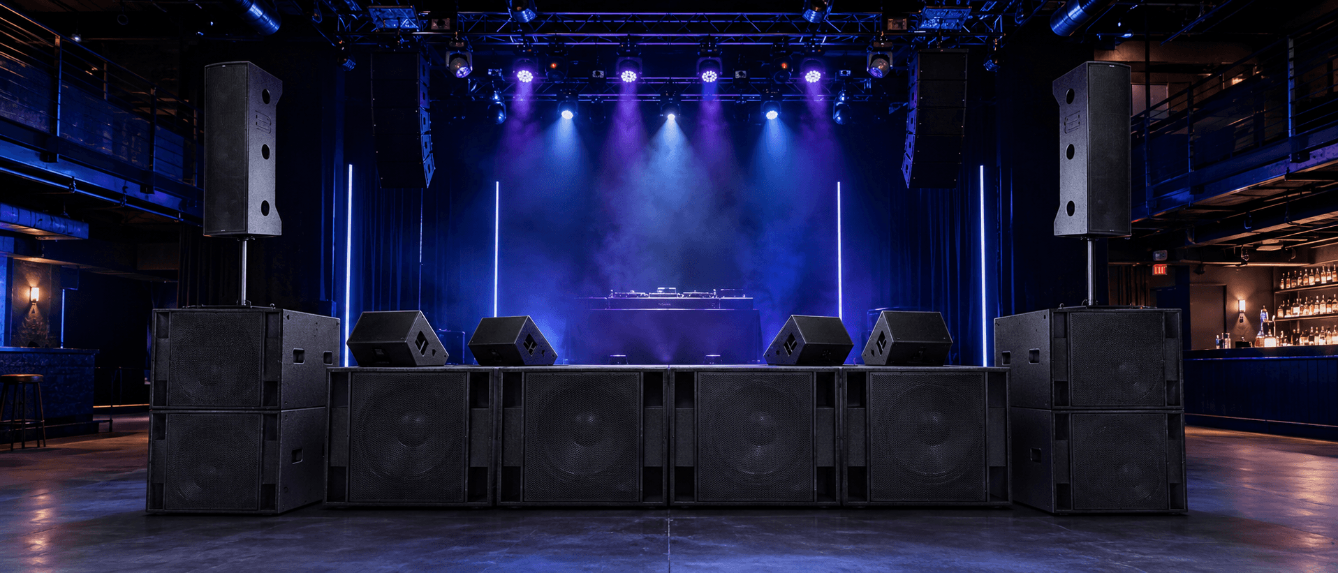 Stage with DJ setup, speakers, and purple lighting