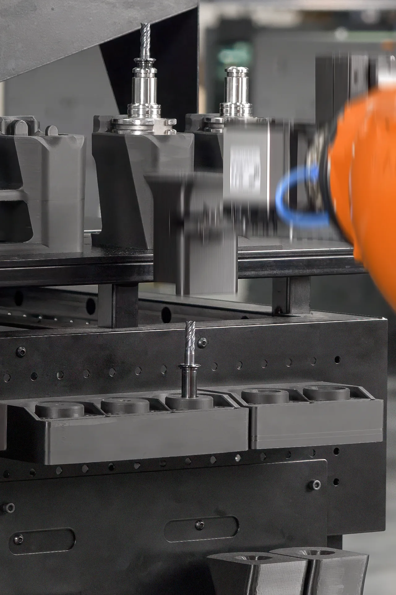 The robotic arm is removing the guiding funnel, revealing the cutting tool seated into the collet, and ready to be assembled with the tool holder.
