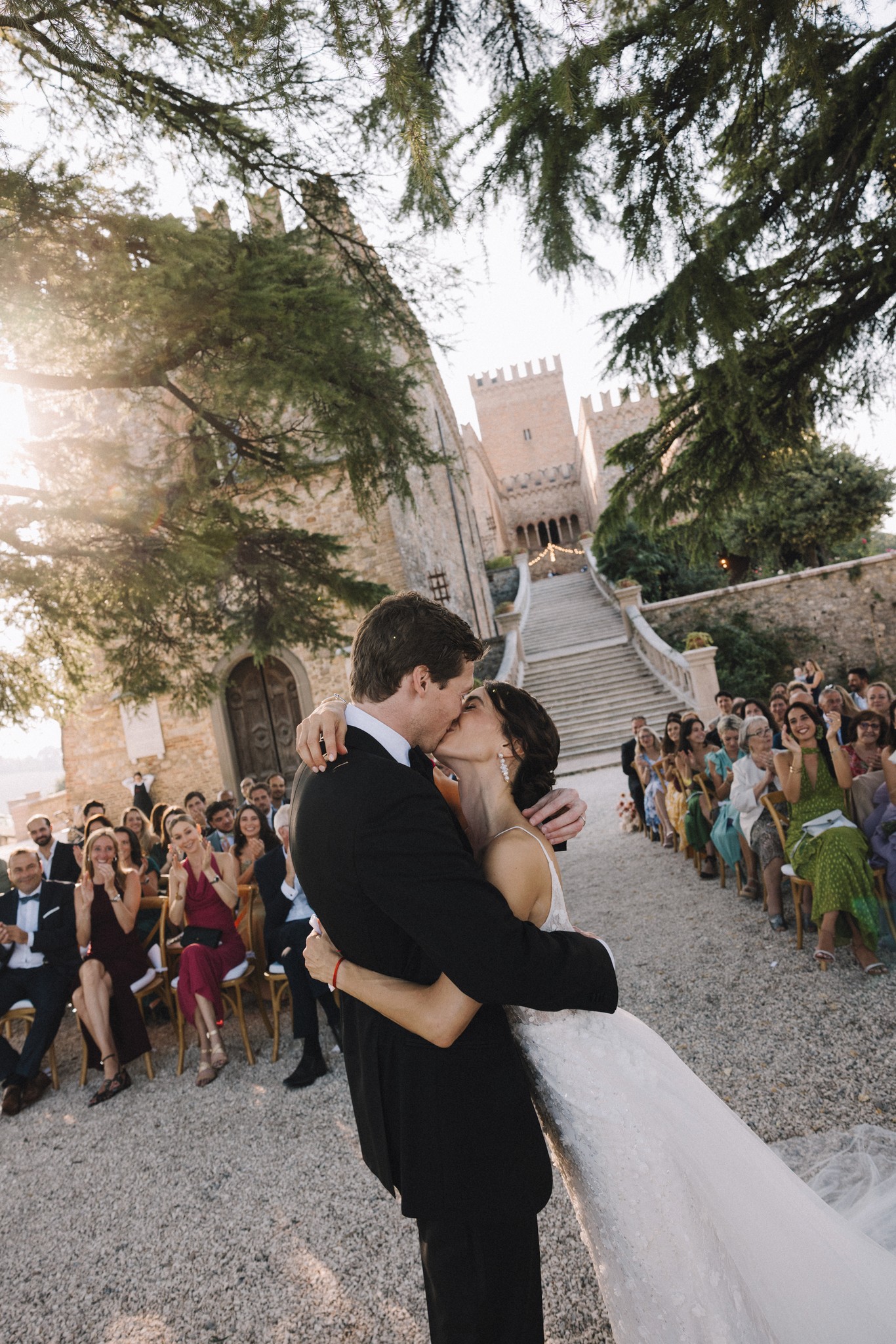 Sposi si baciano al Castello di Tabiano tra gli ospiti e la luce dorata di settembre, reportage Fotolize