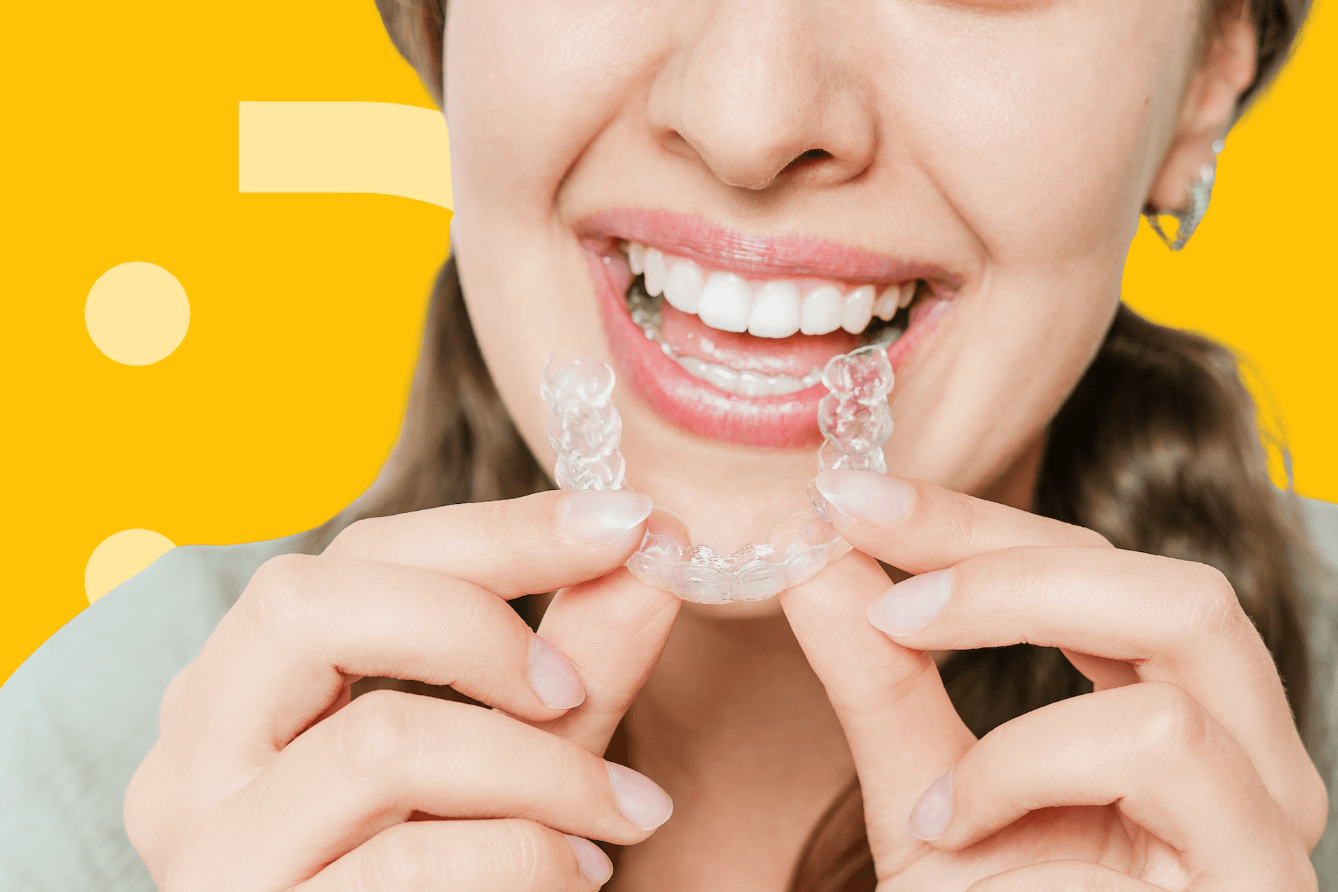 mujer sonriendo colocando sus alineadores dentales
