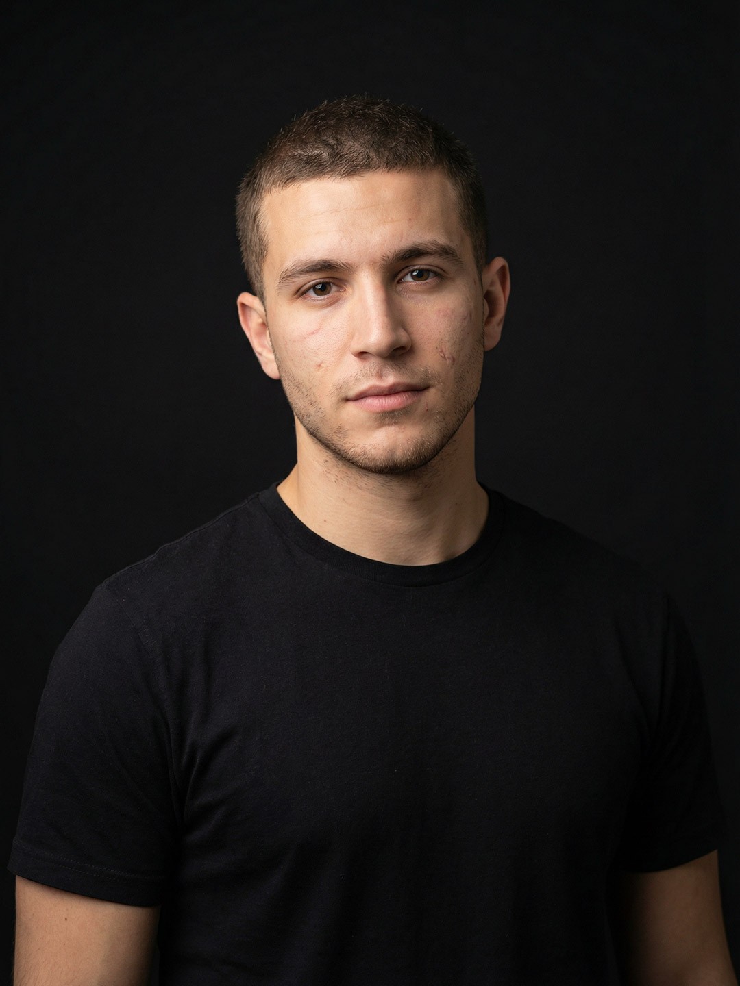 Portrait of a laughing person with curly hair wearing a white shirt