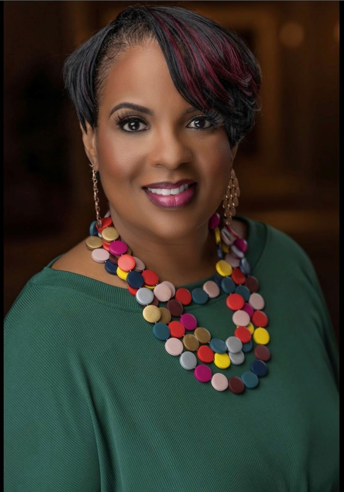 Twyla Garrett, adorned in colorful jewelry and a green shirt, symbolizes a new era for small businesses in enterprise contracts.