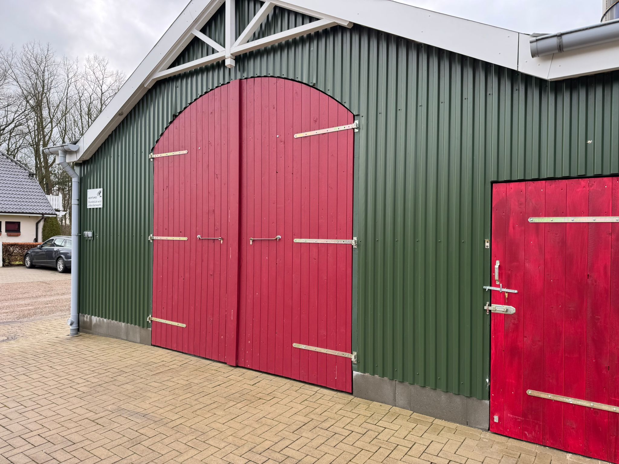 a storage building with red doors and a sky background