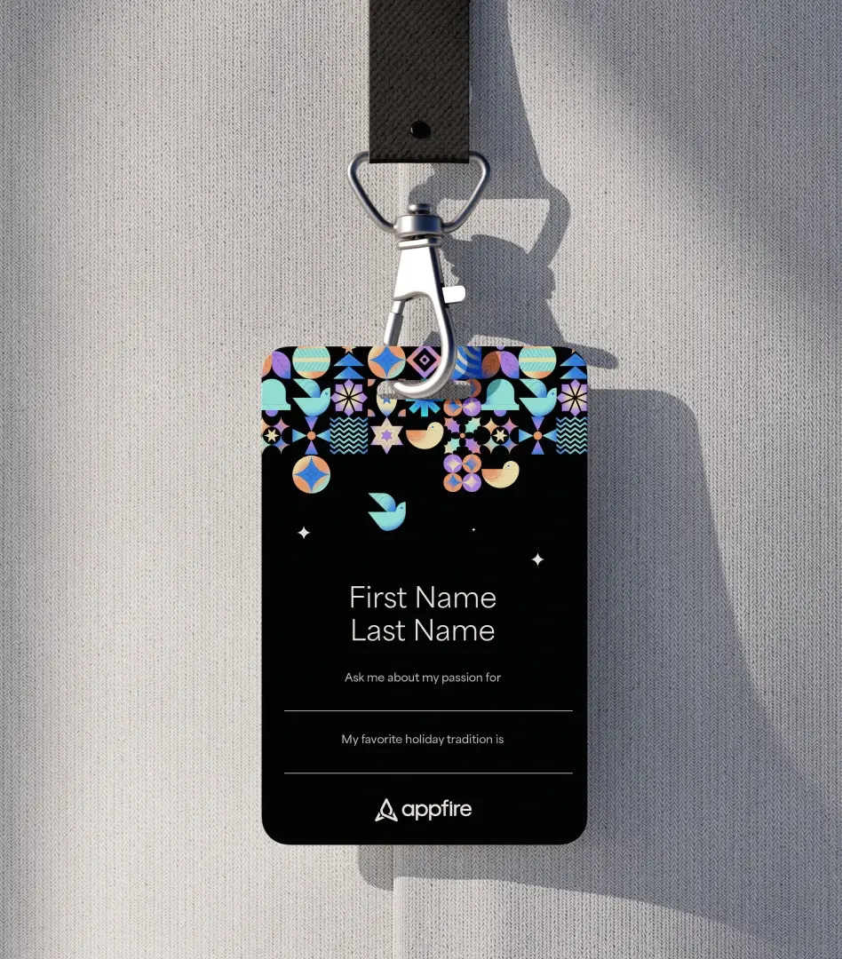 Event badge on a lanyard with colorful holiday icon patterns and fields for first name, last name, and fun facts, topped with the Appfire logo.