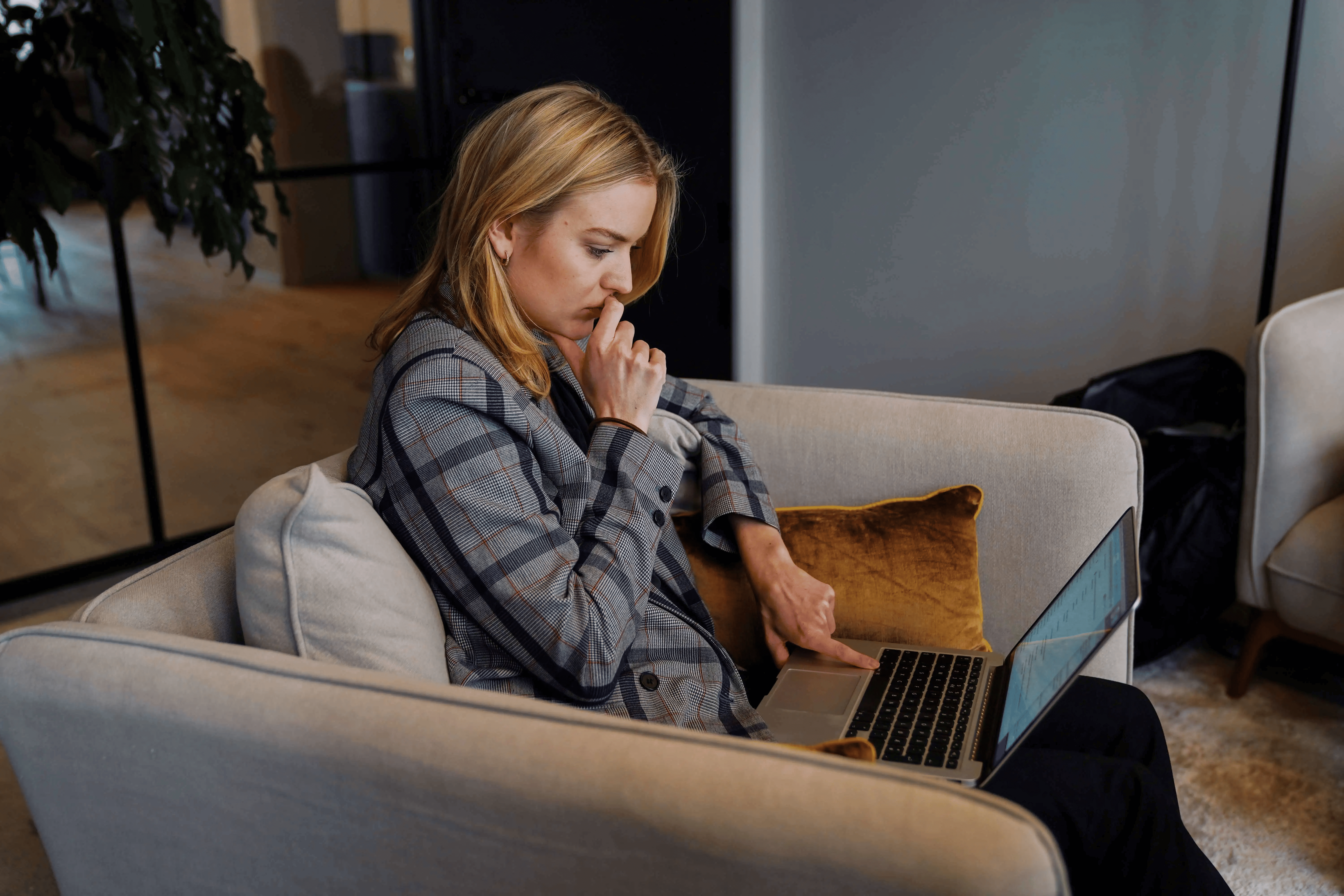 Woman working from couch with laptop in office for recruiters showing hybrid work