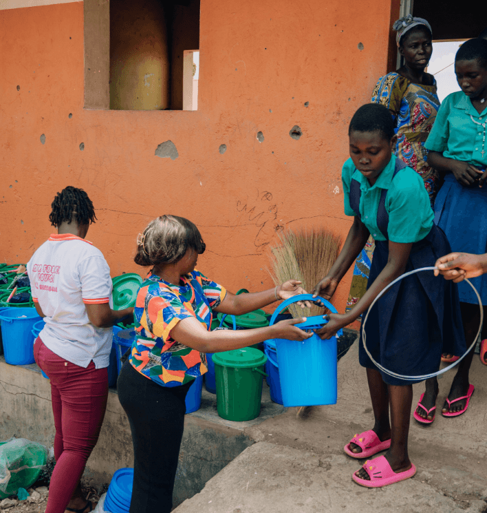 Students and SHE FOR SHE team members helping distribute the pads.