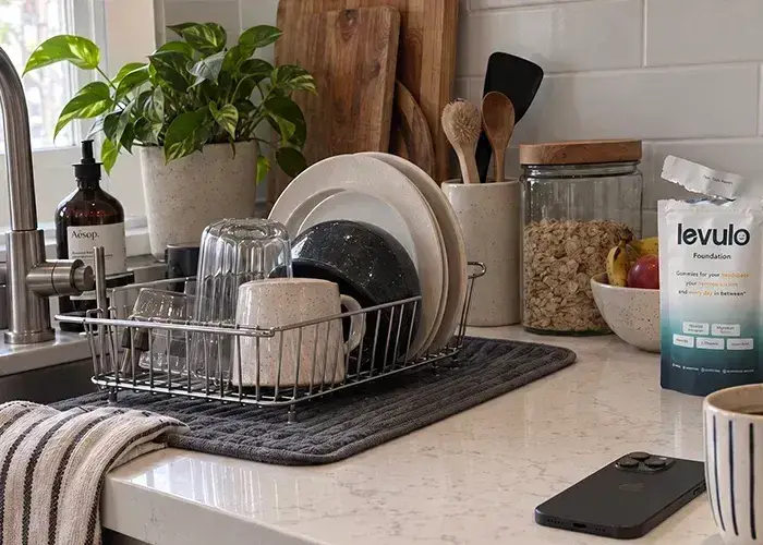 A pile of dishes cleaned with LEvulo Foundation pouch in the background