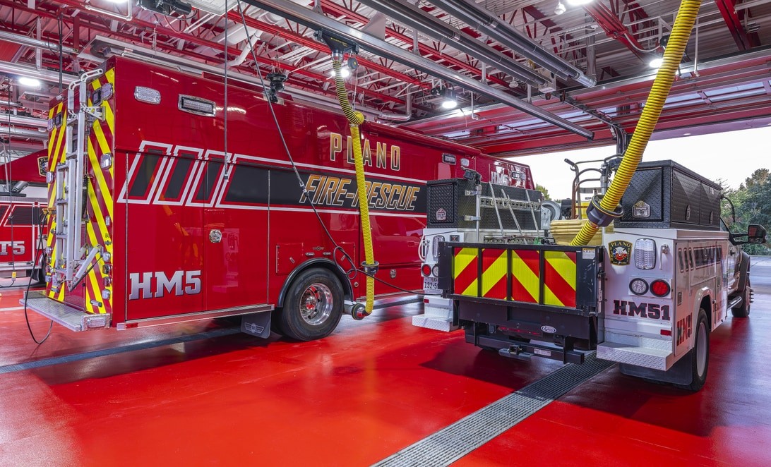 Apparatus bay with hazmat trucks parked nose to tail at Plano Fire Station 5, by Martinez Architects.