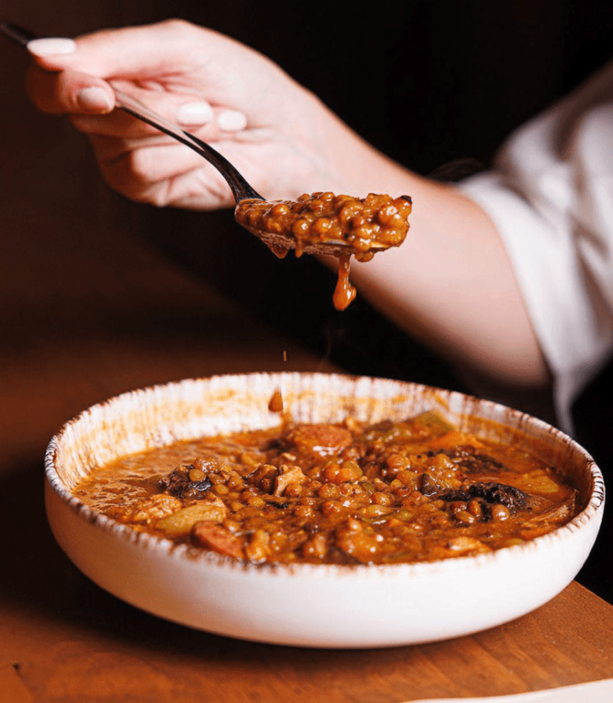 A serene spa setting with two lounge chairs beside a warm, reflective pool and soft, natural lighting.