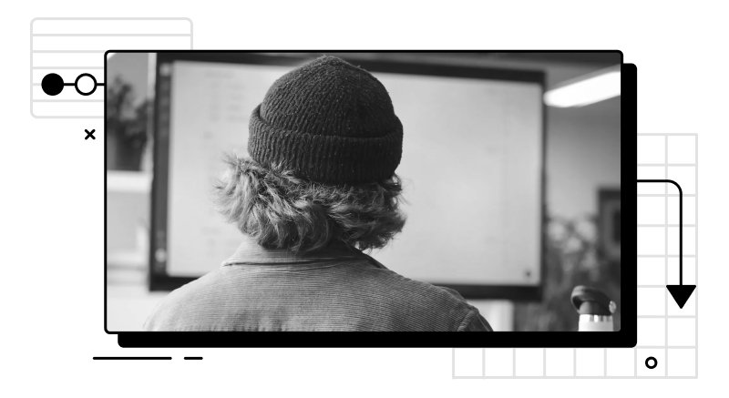 Person in a beanie looking at a projector screen.