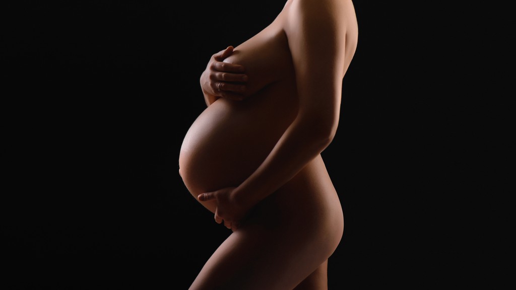 Close-up of a woman's hands adorned with rings and layered necklaces, highlighting her smooth skin and elegant jewelry