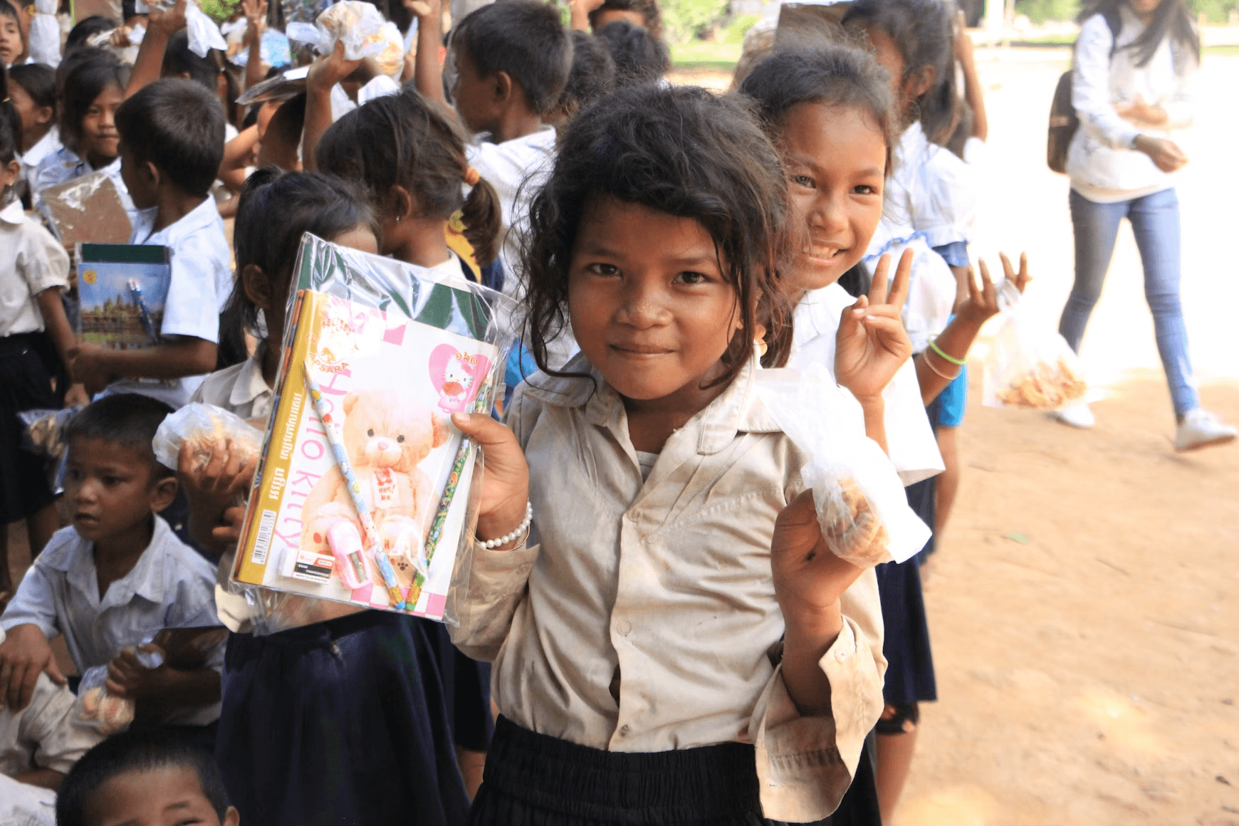 Girl in light-colored shirt holding Hello Kitty item.
