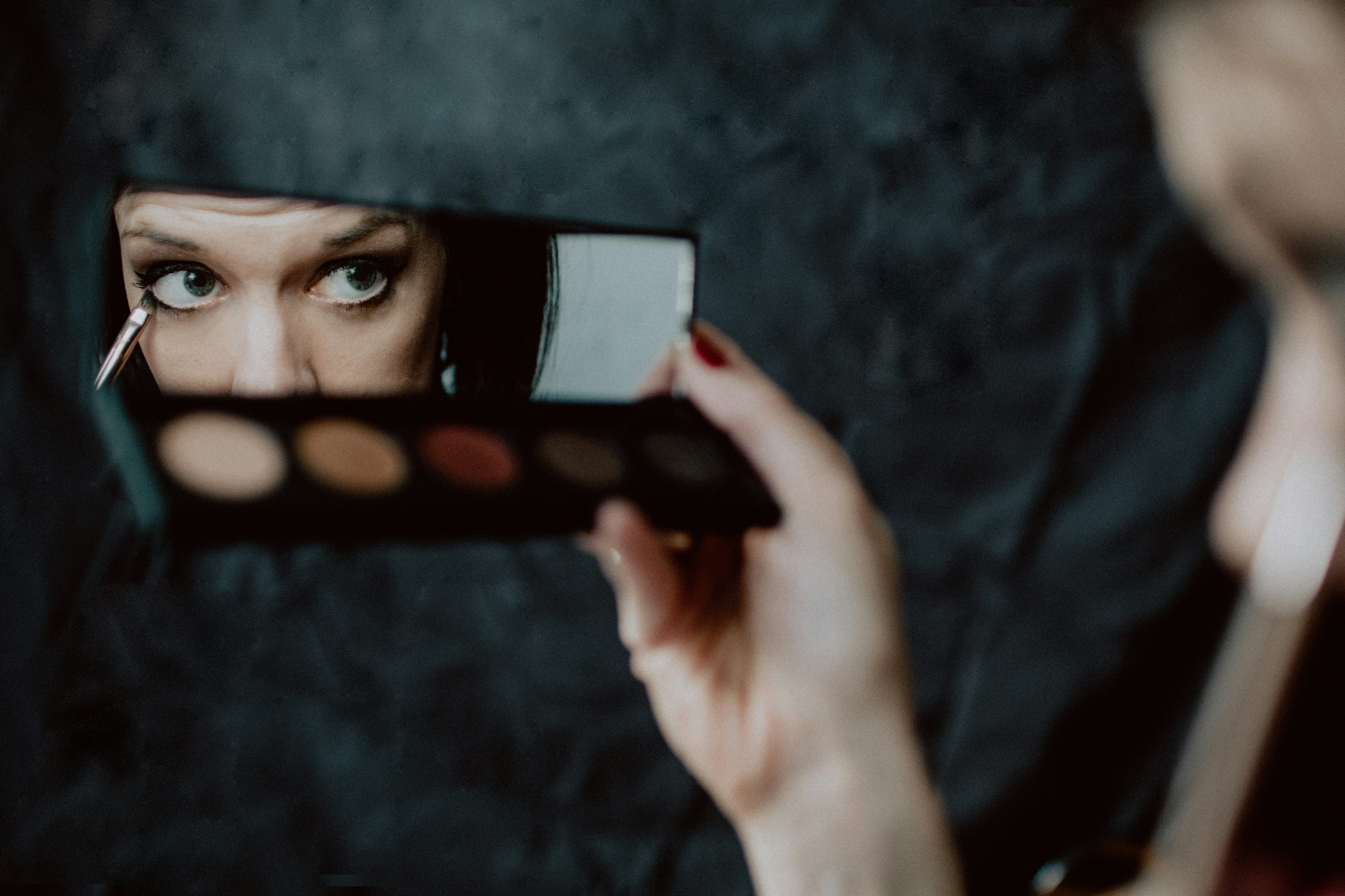 woman using eye liner - How To Glow Up