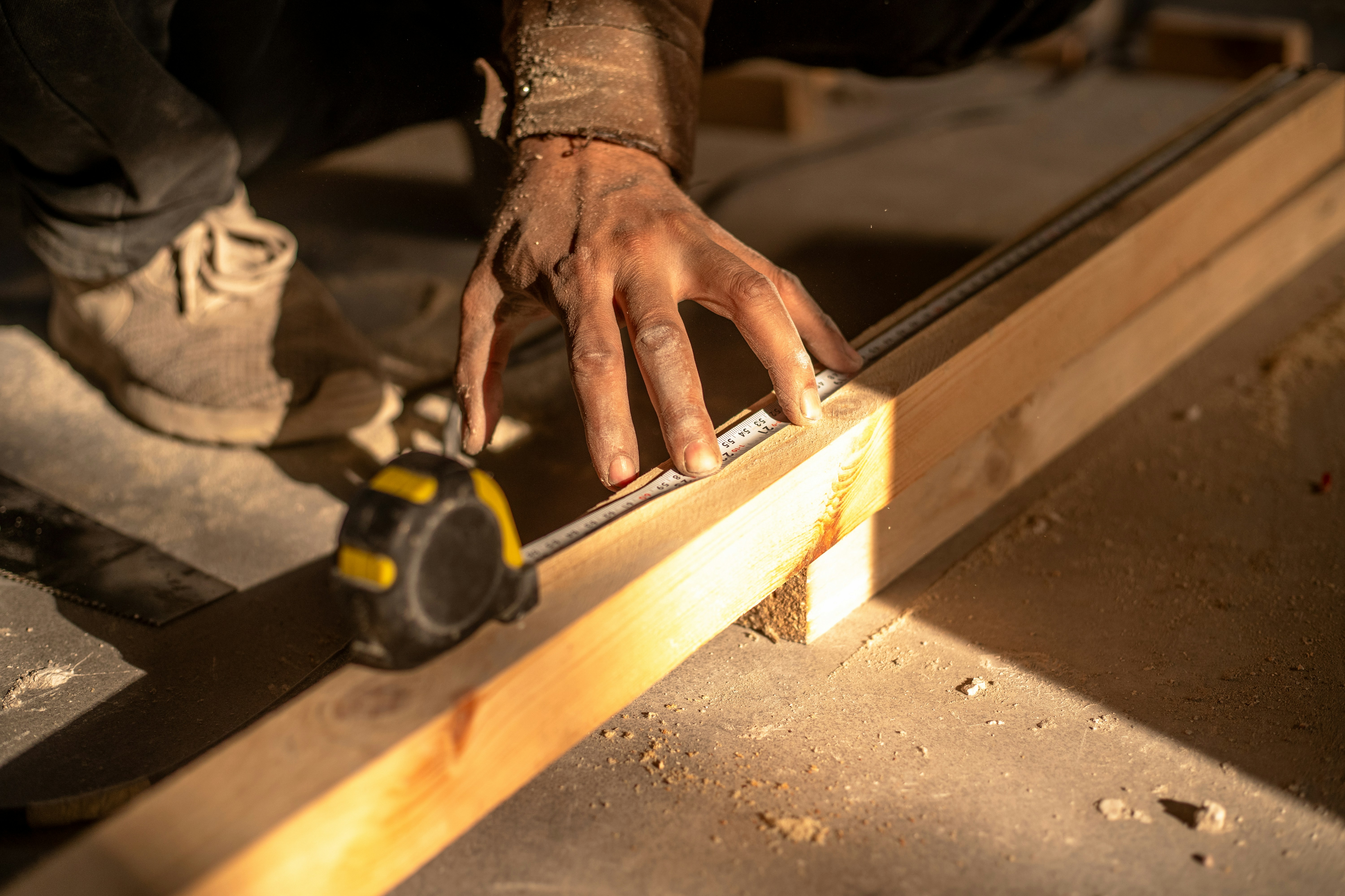 A man using a circular saw to cut a piece of wood