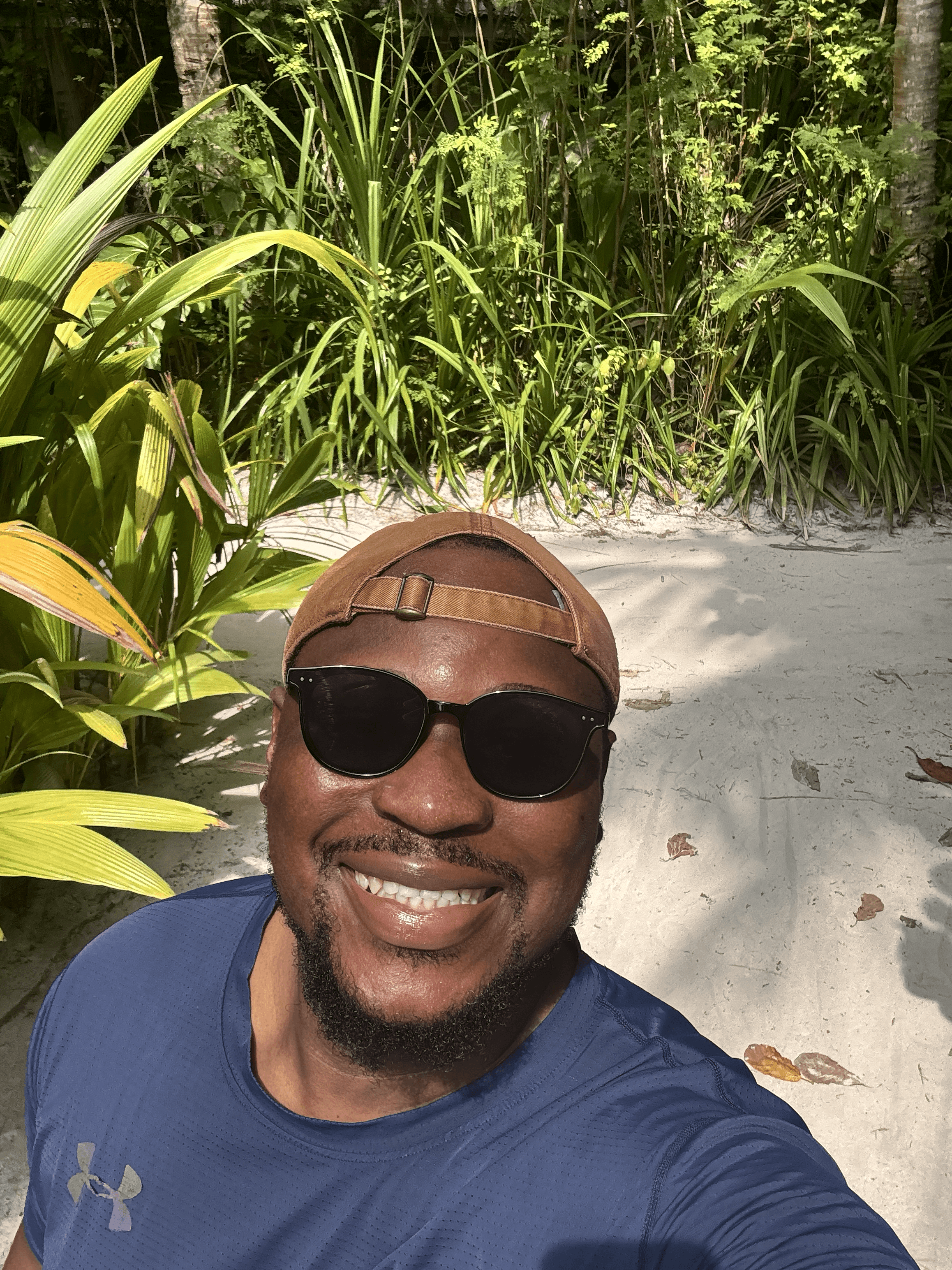 A person with wavy light hair stands facing slightly to the left, wearing a striped shirt against a neutral background.