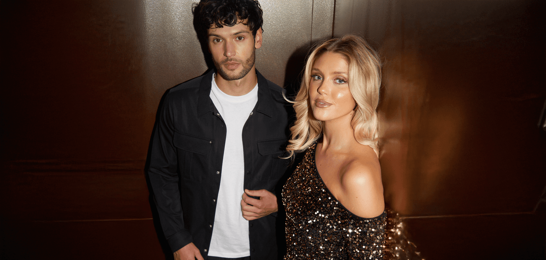 A young man and woman in a fashionable clothes, looking at the camera