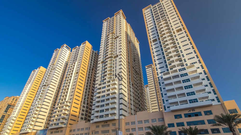 Upward view of the iconic residential towers against a clear blue sky. A top choice for real estate investors.