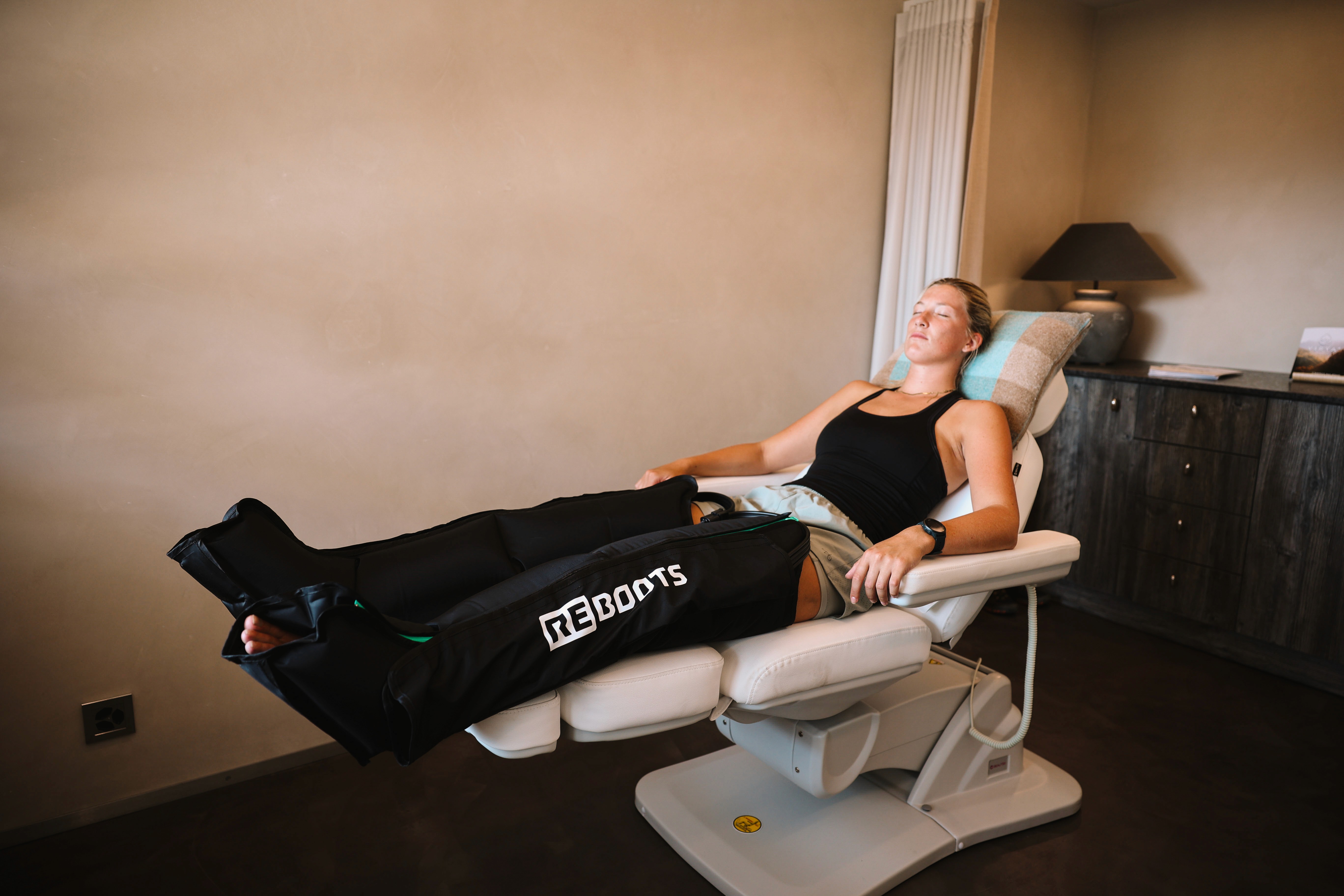 Girl sitting in a chair with compression boots on