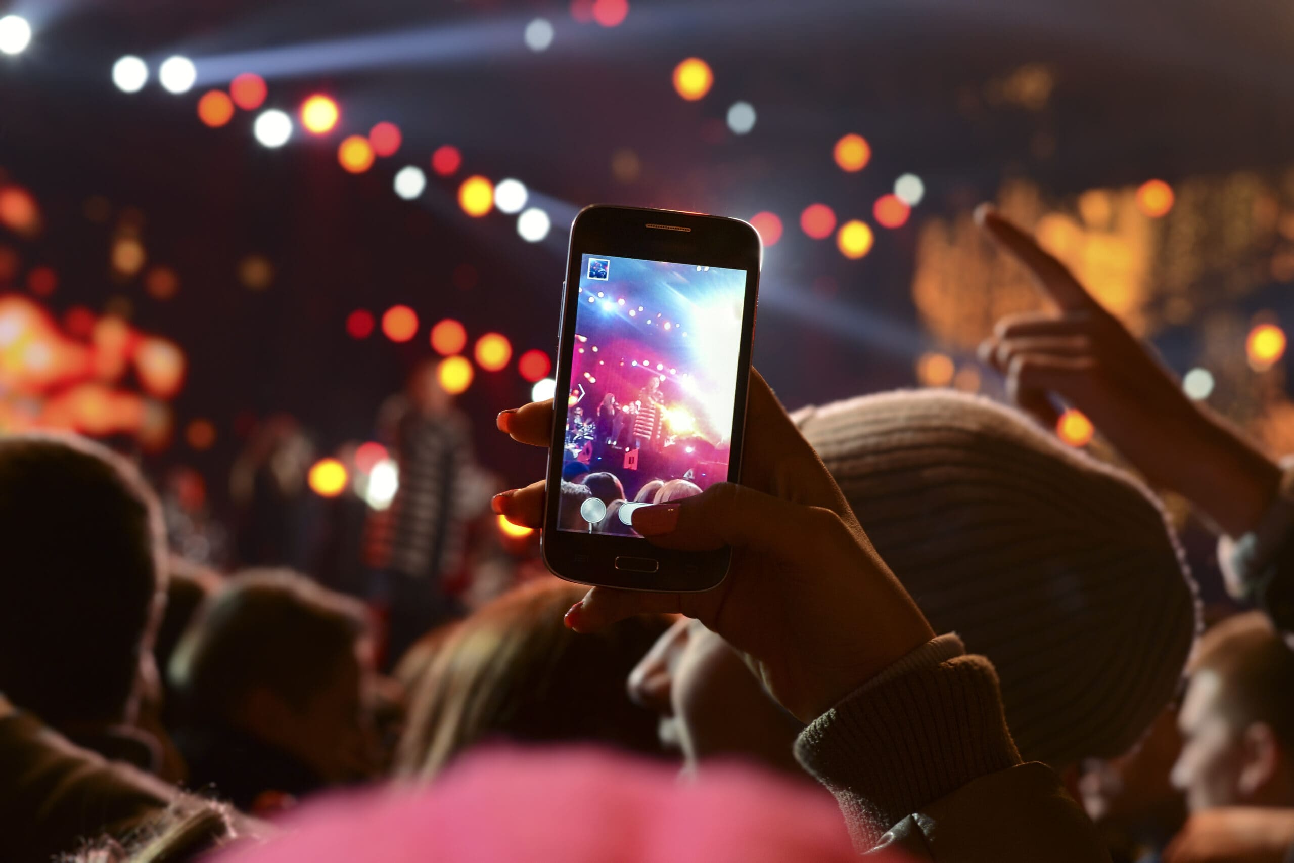 People holding their smartphones and photographing concert