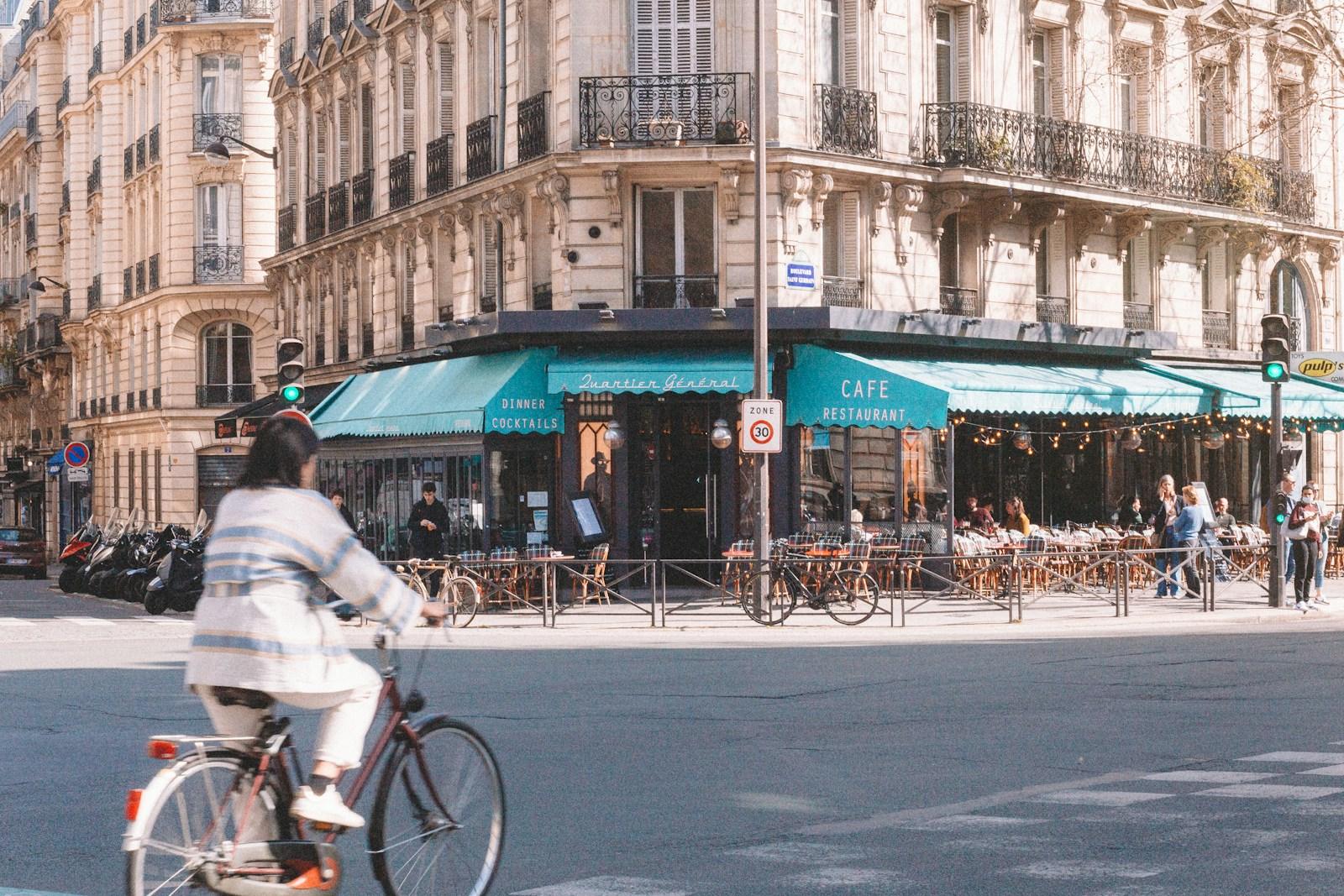 A man riding a bike down a street next to tall buildings