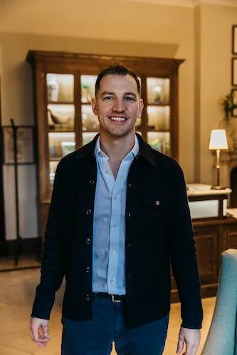 A person smiling and posing in a studio apartment.