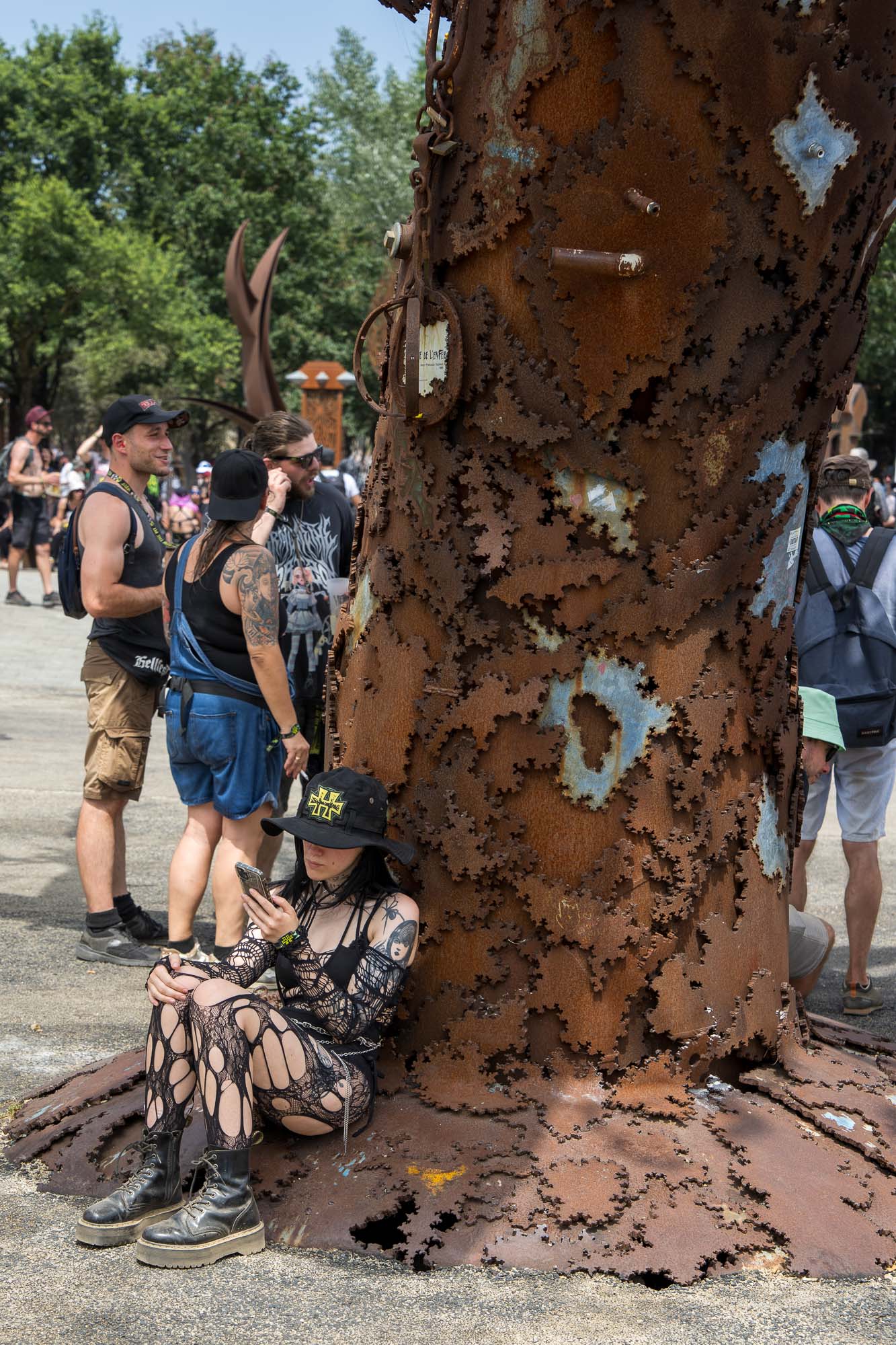 Chanteuse penchée au bord de la scène, micro à la bouche, devant le décor urbain du Hellfest 2026