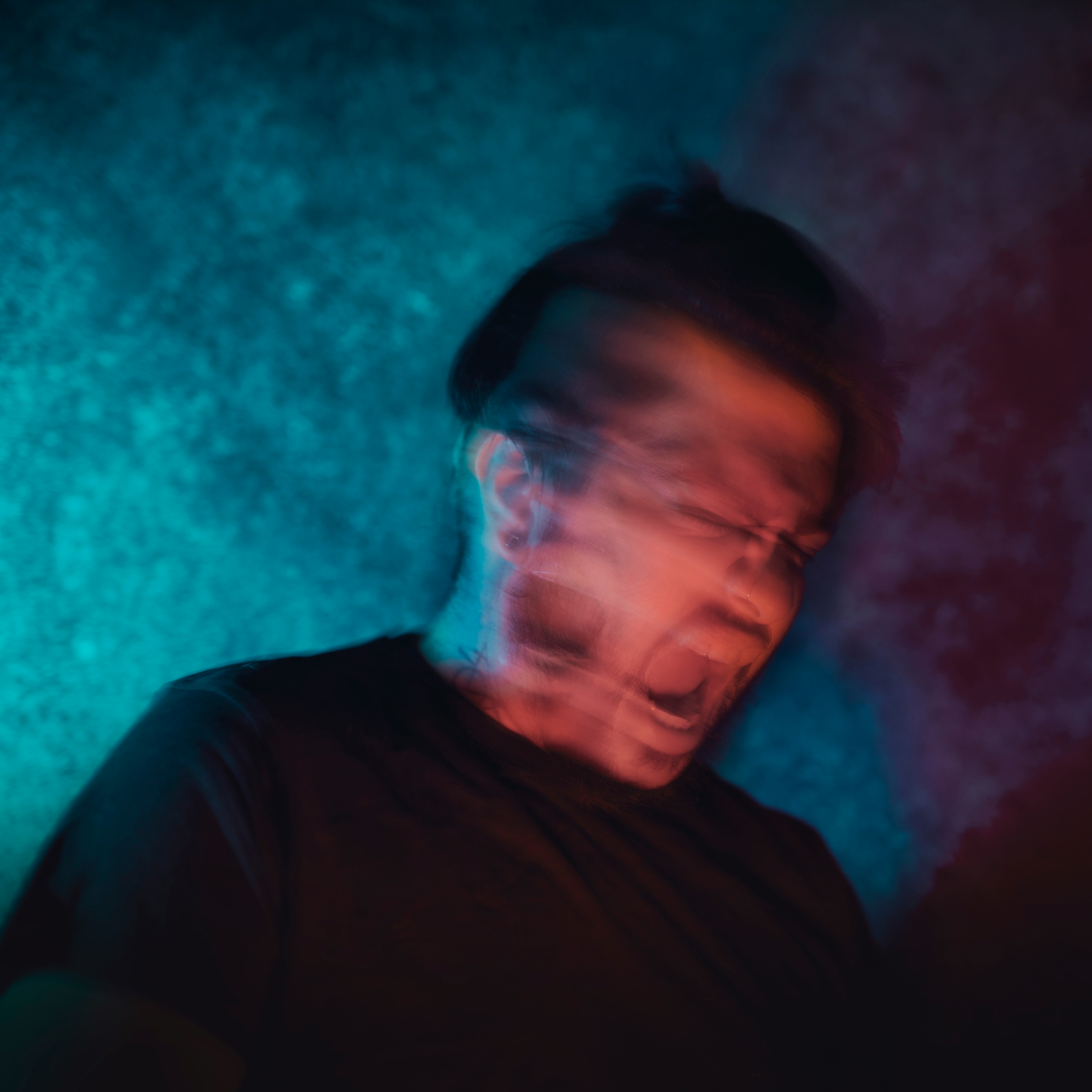 a man in a dark room with his eyes closed