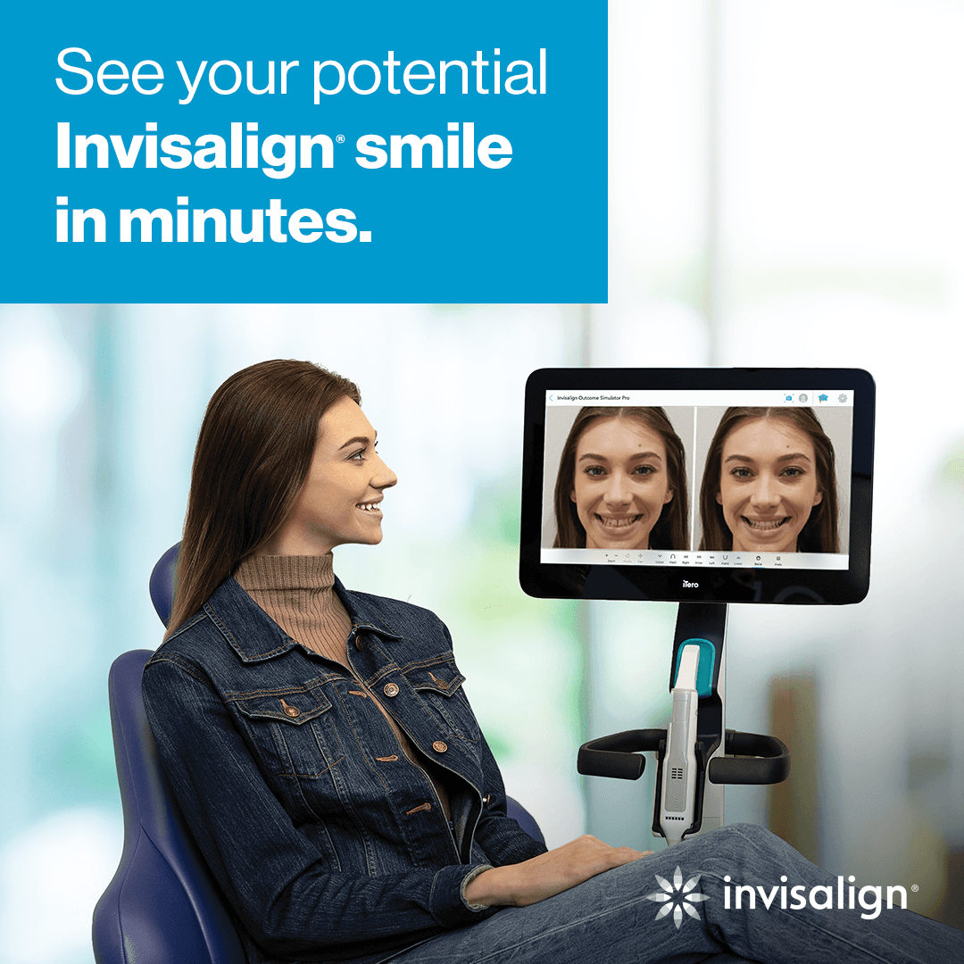 A woman sitting in a dental chair, looking at a computer screen showing a before and after comparison of her potential Invisalign smile