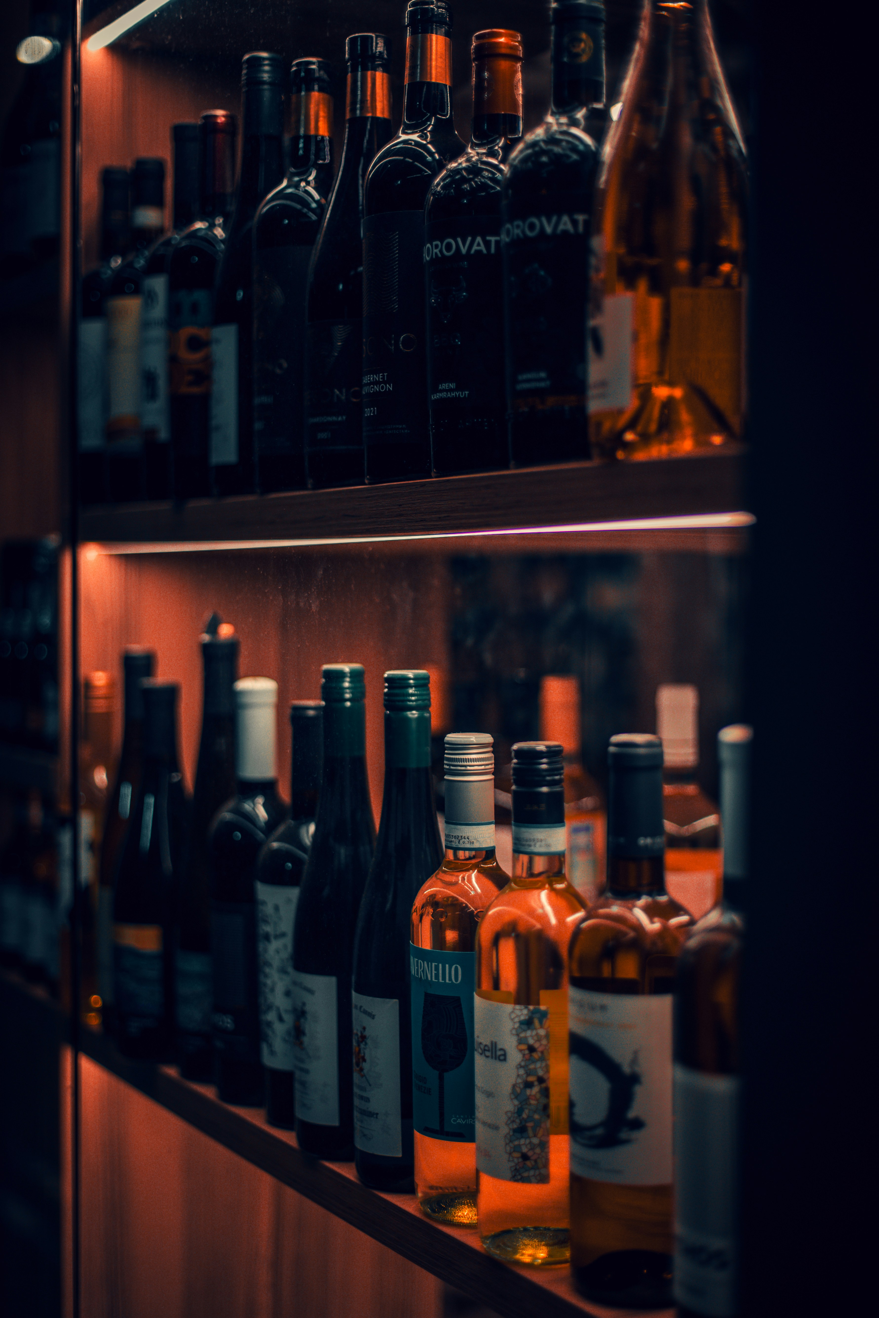 A shelf filled with lots of bottles of wine