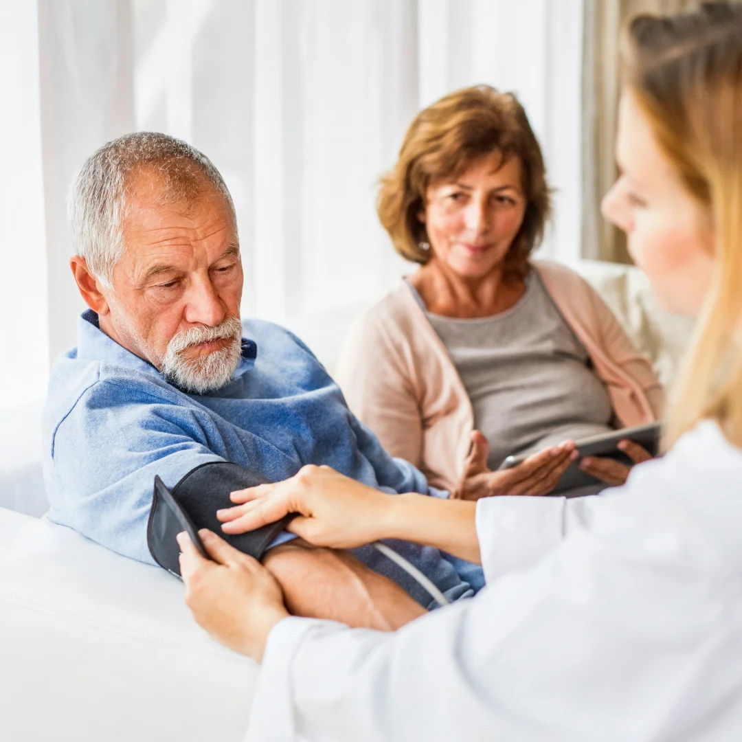 Community nurse with older man and family member discussing care at home in Brisbane