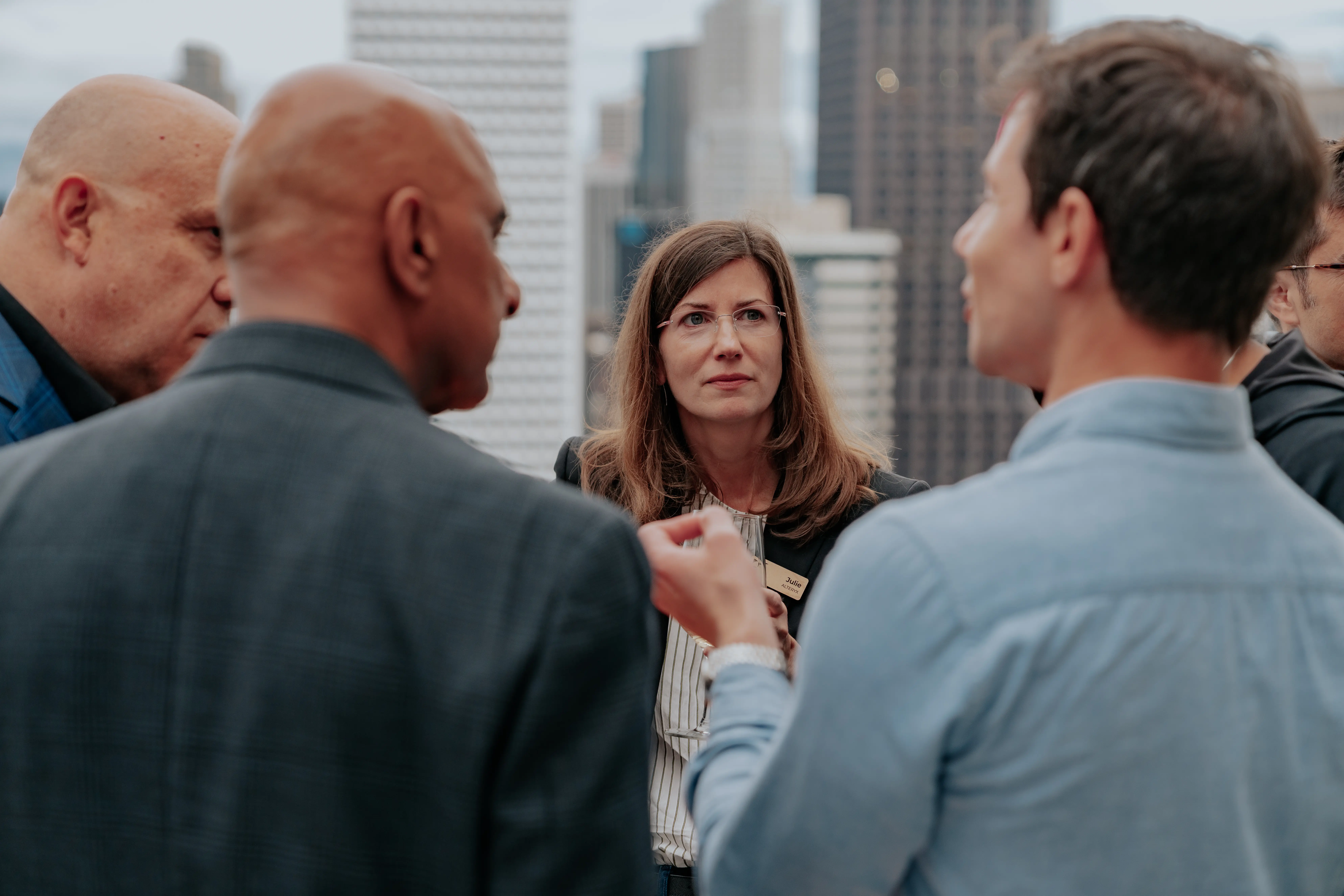 People standing and talking near a tall building.