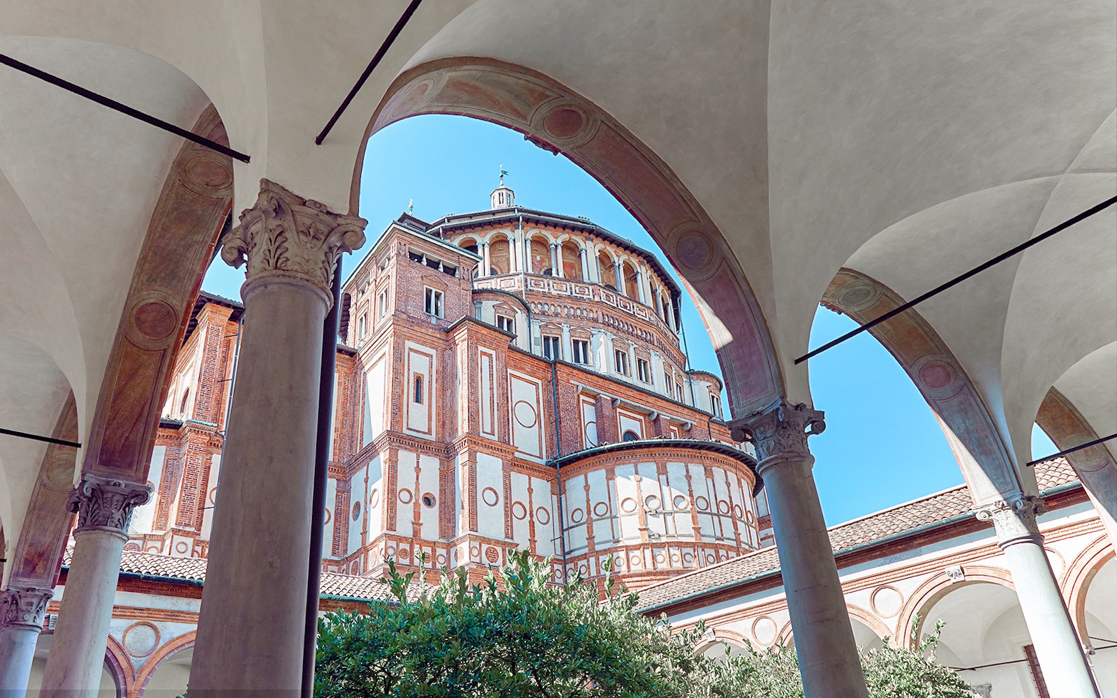 Santa Maria delle Grazie ytra bygging, Mílanó, Ítalía, skoðuð í gegnum bogagöng á leiðsögn um Síðustu kvöldmáltíð Da Vinci.