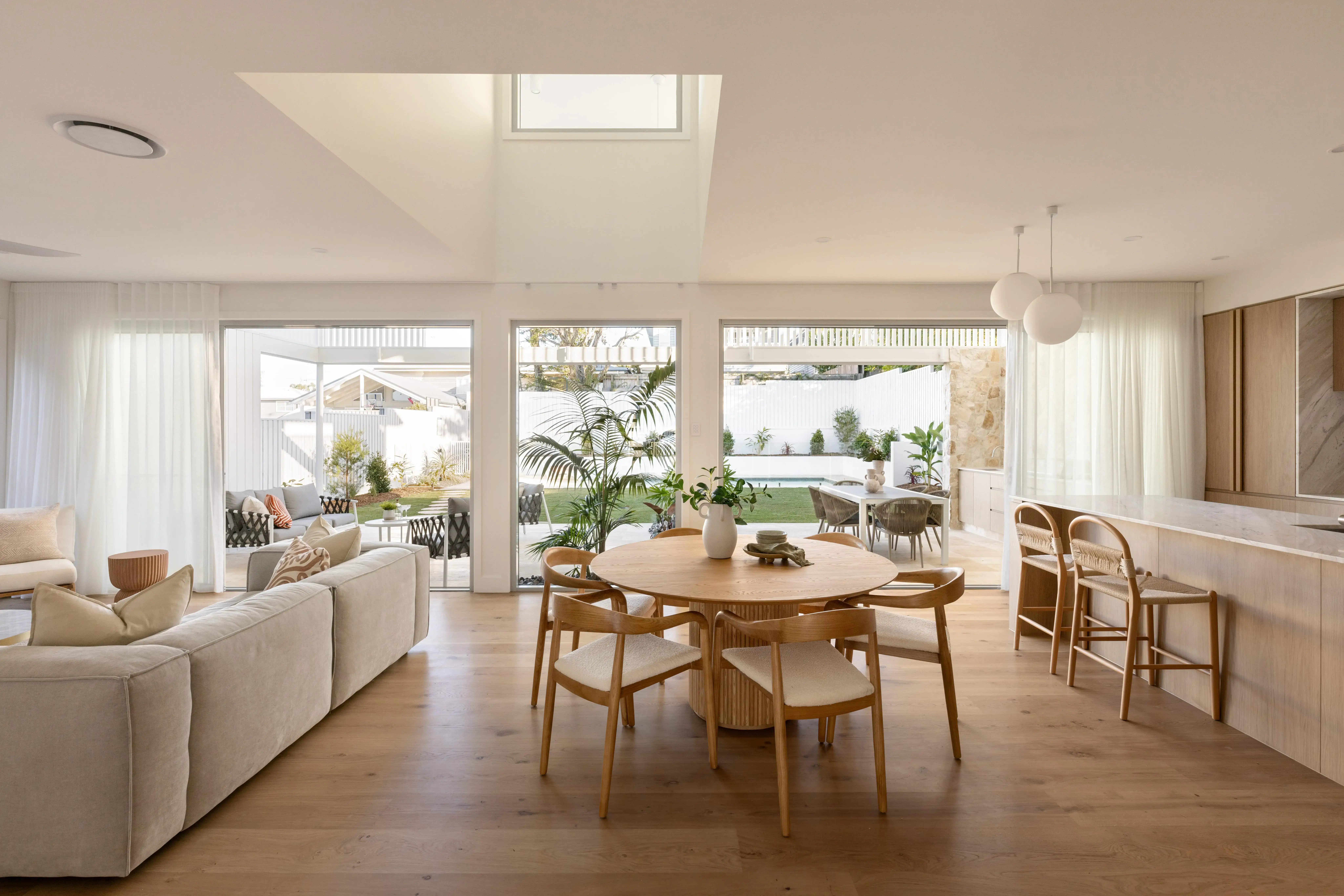 An open plan living space incorporating kitchen, living and dining showing indoor outdoor flow designed by Invilla Architecture