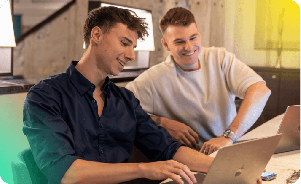 A talent recruiter with a soft smile working on her laptop in the office. The angle is on her face so we can't see what's is on the screen. She is wearing a blazer 