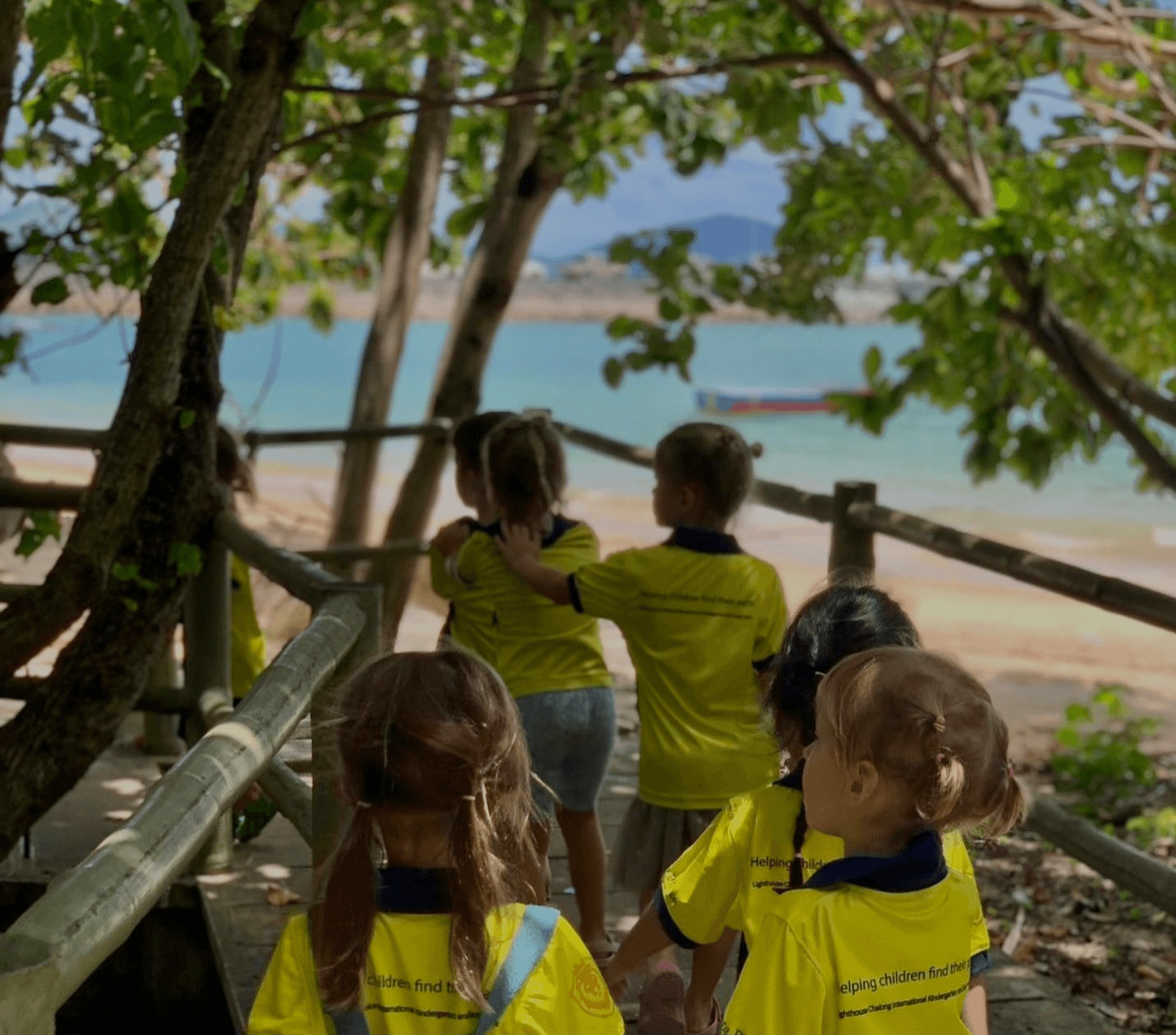 Children in school uniform follow each other with their hands on each other's shoulders