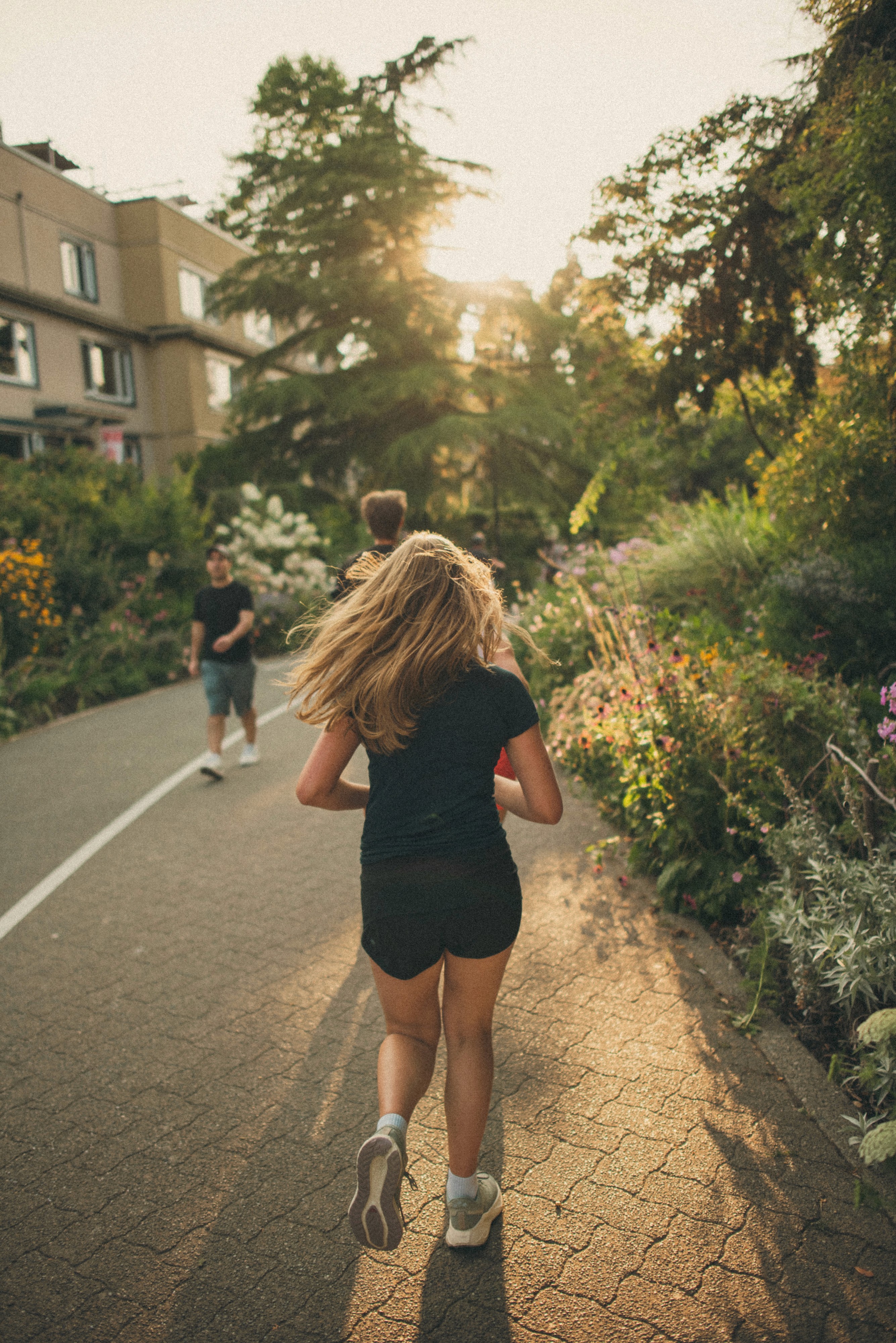 Man wearing a neon yellow cap with "pyra." logo and a red athletic tank top, adjusting his hat with both hands.
