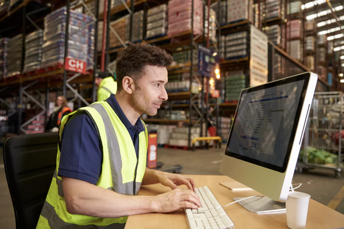 A man checking stock on the computer in the warehouse