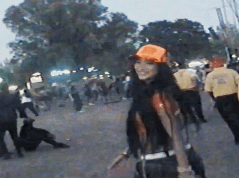 Dancer in black outfit with arms raised, arching backwards