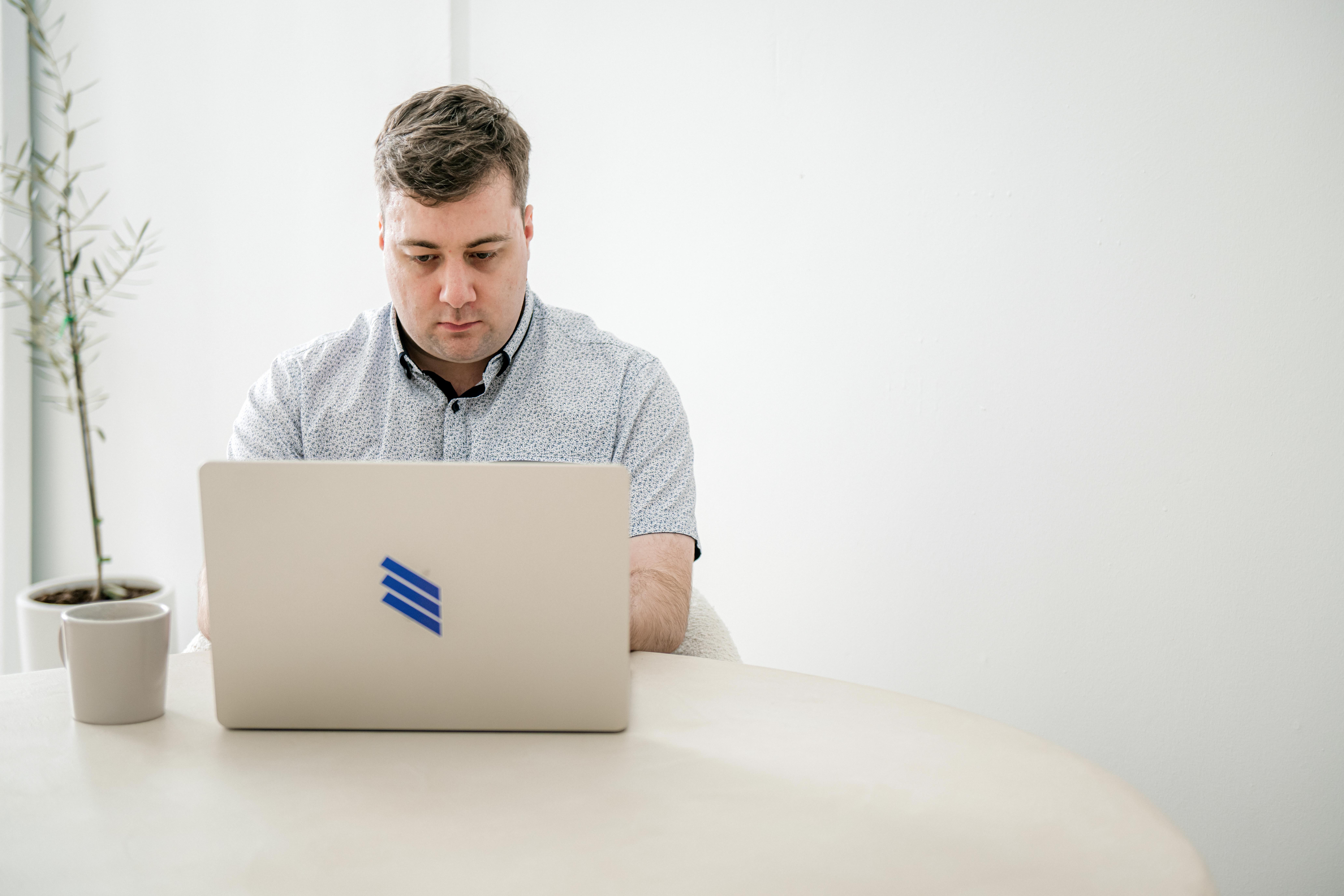 Black and white image of people working at a table with laptops, showing hands gesturing during discussion of digital content displayed on screens, with fabrica® logo in the corner.