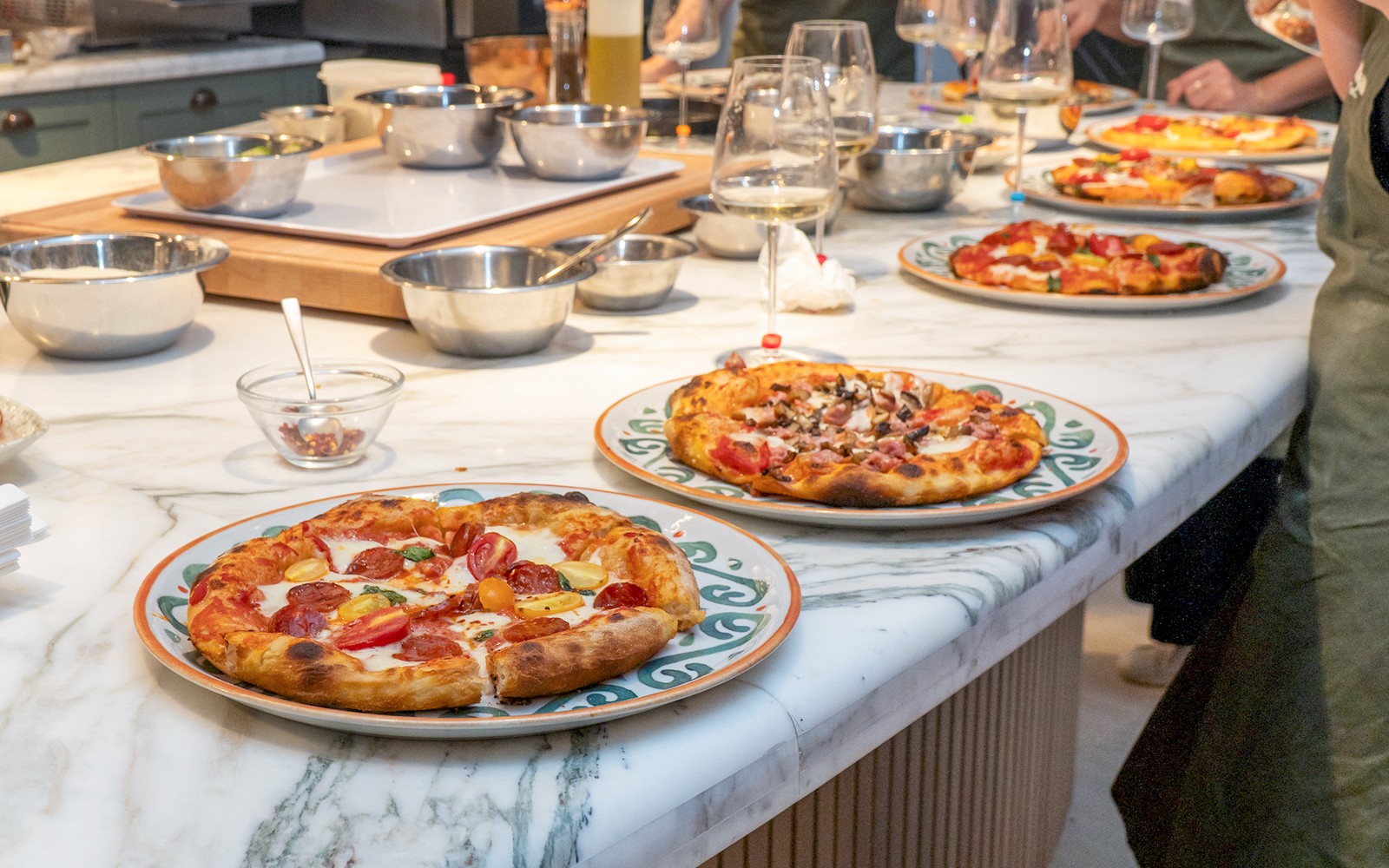 Freshly baked pizza on a wooden table during a pizza-making class in Rome.