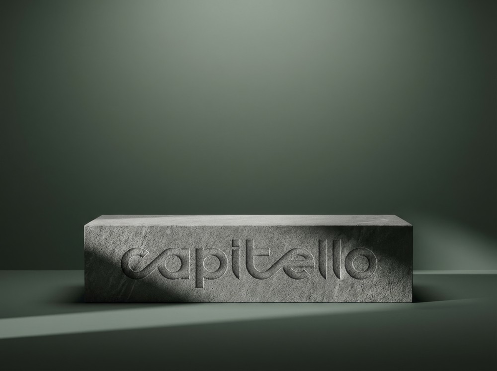 Capitello Finans branded business cards arranged at an angle on a light surface with soft directional lighting, showcasing the print identity system.