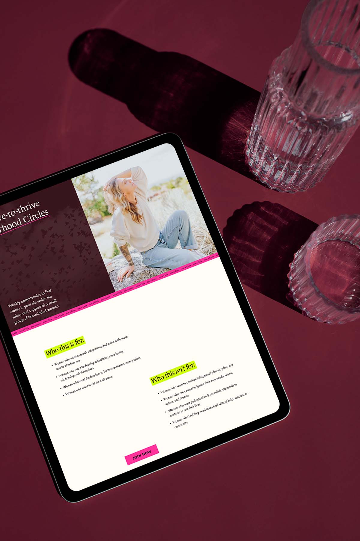 A top down view of a tablet sitting on a tabletop with two waterglasses beside it, a publishing company's website is on the screen
