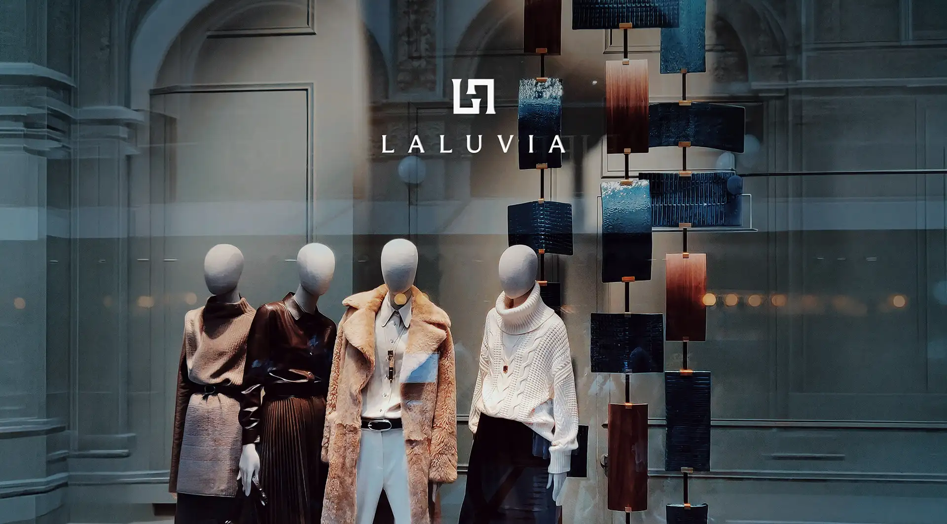 High-end Laluvia boutique window display featuring mannequins styled in premium winter outerwear and elegant knitwear.