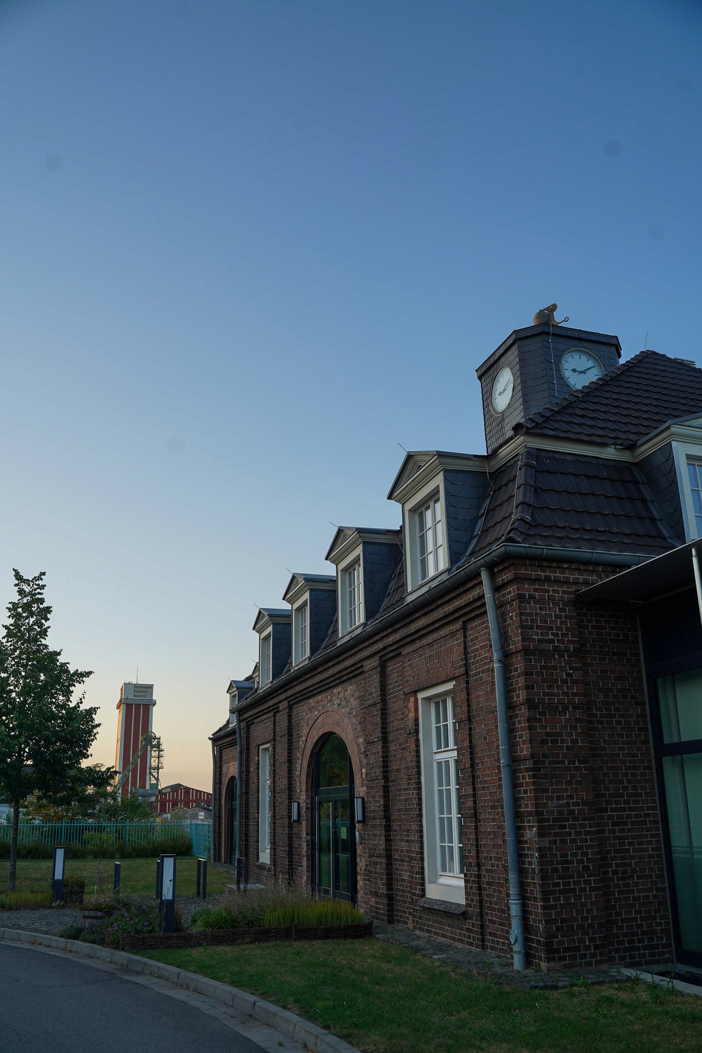 Abendaufnahme des Schirrhofs mit weichem, warmem Licht. Im Hintergrund sind die beiden Zechentürme von Kamp-Lintfort zu sehen.
