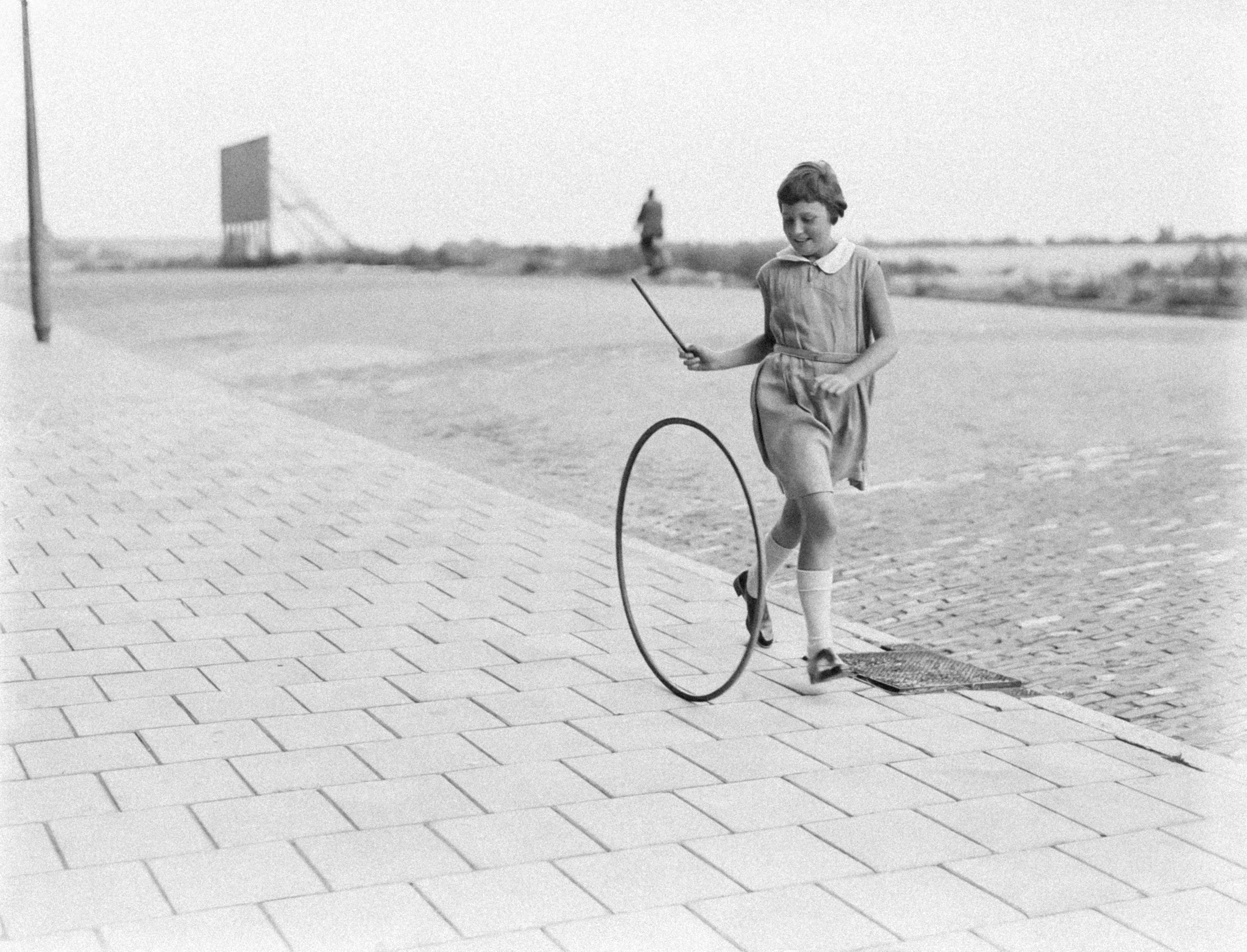 A girl playing with a hoop and stick