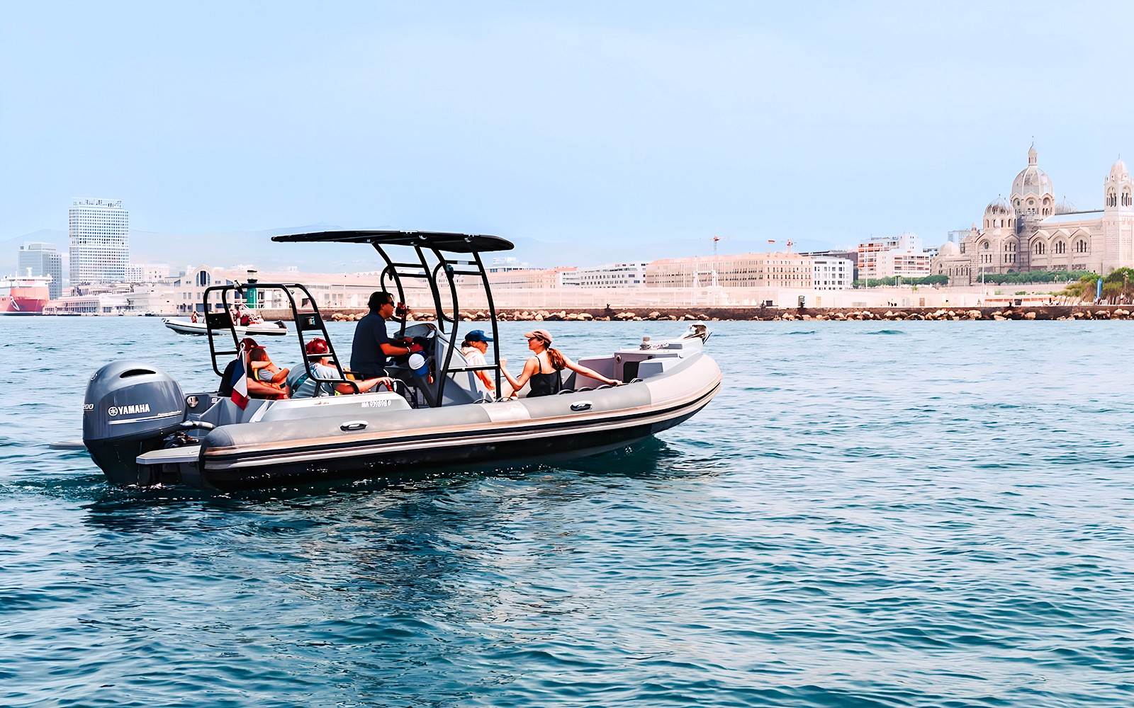 Boat tour in Marseille with view of Notre-Dame de la Garde and city skyline.