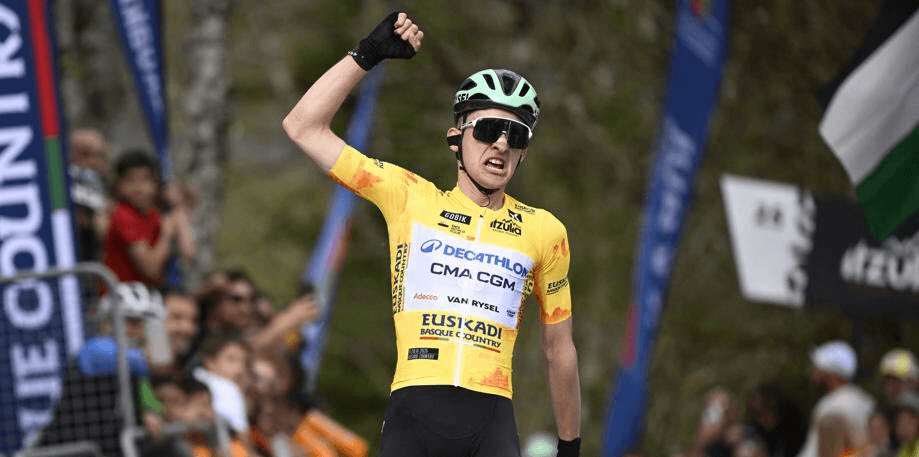 Paul Seixas lève le poing en franchissant la ligne, en maillot jaune de leader Decathlon-CMA CGM